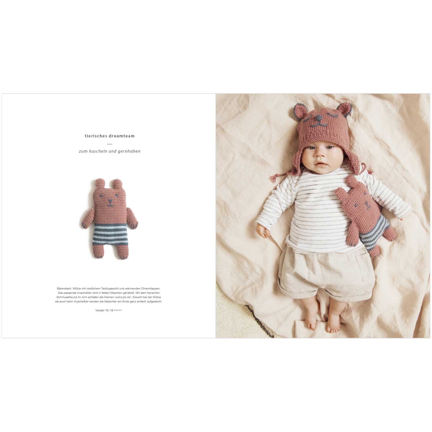 Rico Baby Heft Nr.26: Ein Baby in cremefarbener Kleidung mit passendem rosa Mützen-Set und Kuscheltier.