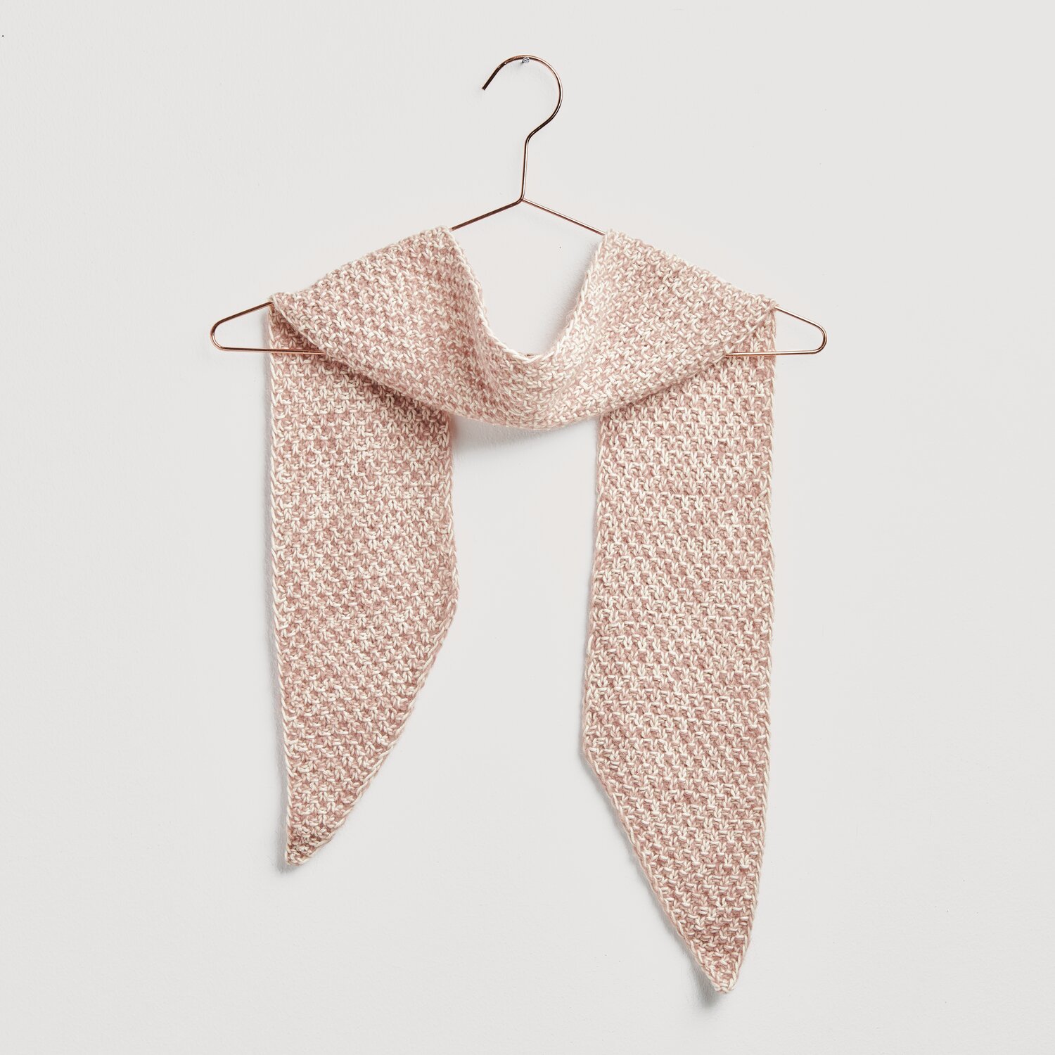Strickset Mini-Tuch Modell 19: Ein zartes, gestricktes Tuch in Altrosa, aufgehängt an einem Kleiderbügel. Ideal für Frühling und Sommer.
