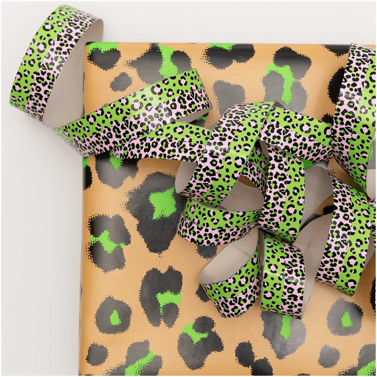 Luftschlangen Acid Leo silber 3,8m von Rico Design auf Geschenkpapier mit Leopardenmuster.