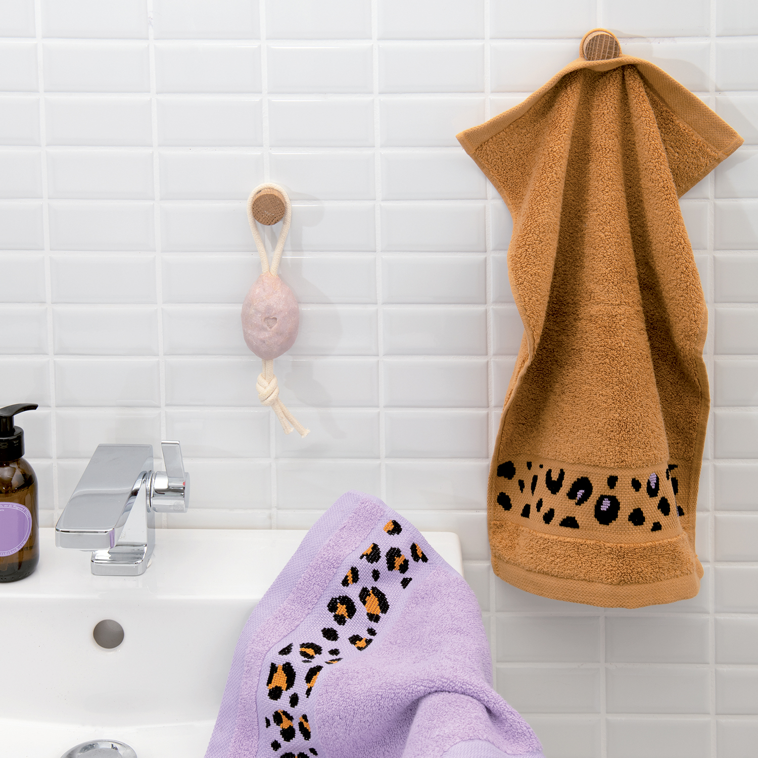Stickanleitung Handtuch im Leo-Design: Zwei Handtücher mit Leopardenmuster in einem modernen Badezimmer.
