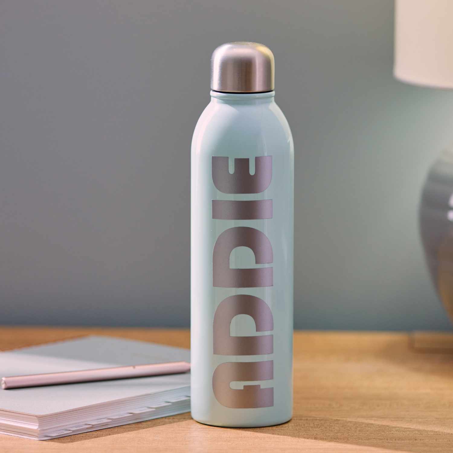 Joy Smart Vinyl Permanent 13,9x121,9cm auf einer Wasserflasche mit silbernem Deckel auf einem Tisch.