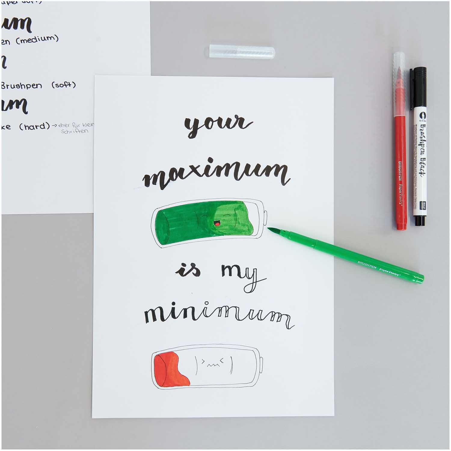 Paper Poetry Brushpen Filzstifte 1-4mm, 12 Stück, auf einem Tisch mit Zeichnung und Stiften.