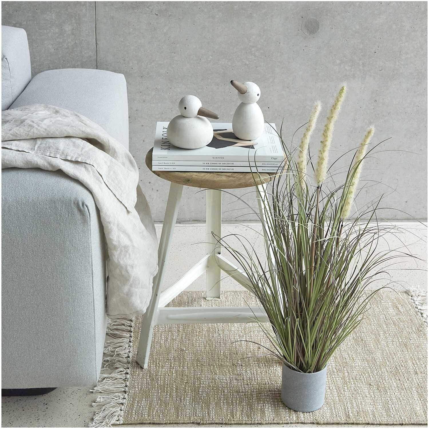 Dünengras im Topf 64cm neben einem hellgrauen Sofa und einem kleinen Tisch mit Deko-Enten, von Rico Design.