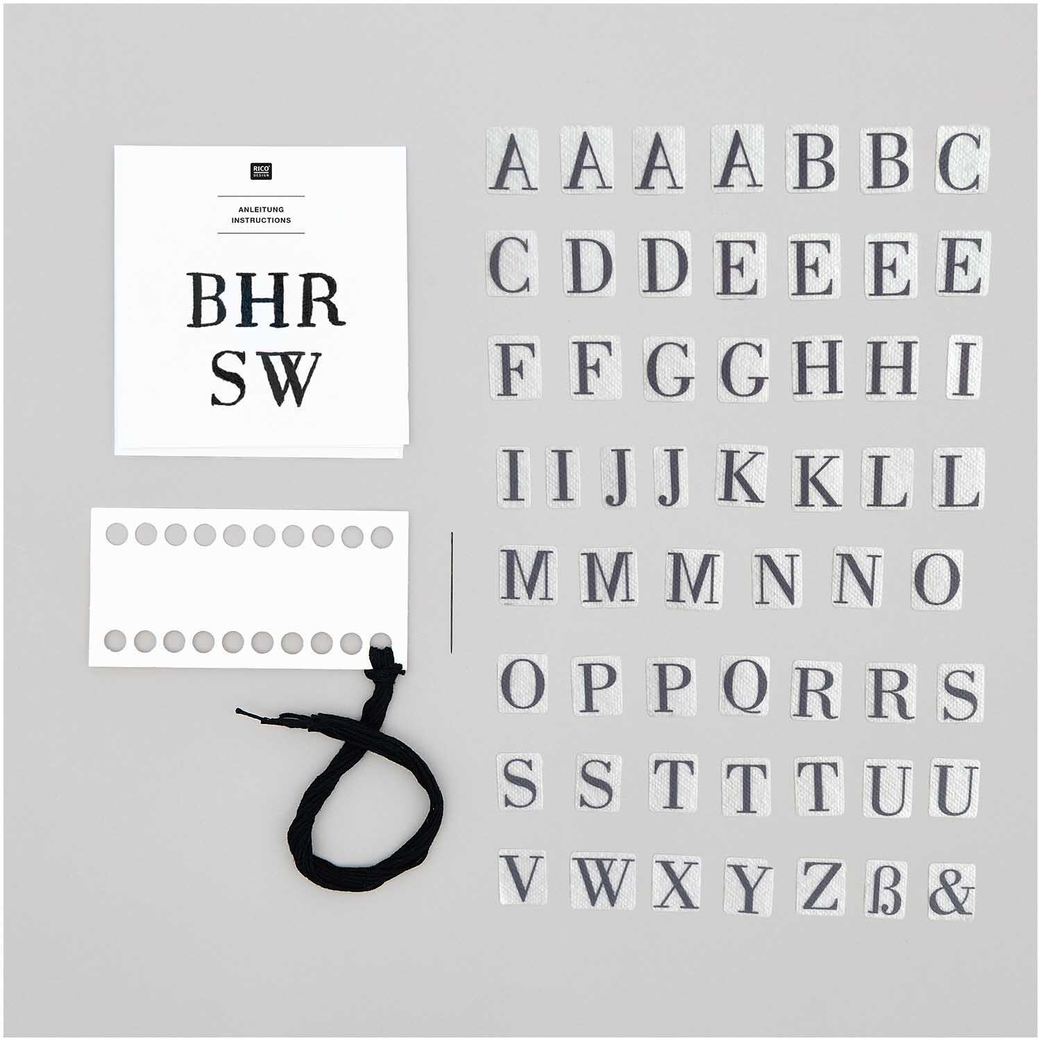 Stick and Stitch Stickpackung Alphabet mit 56 Buchstaben, vorgezeichnet in Schwarz von Rico Design, auf grauem Hintergrund.