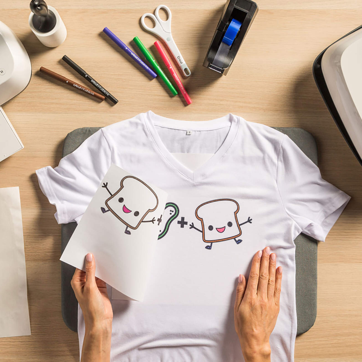 Infusible Ink™-Marker 1.0 Neon von Cricut: Person gestaltet ein T-Shirt mit bunten Markern und Transferpapier.