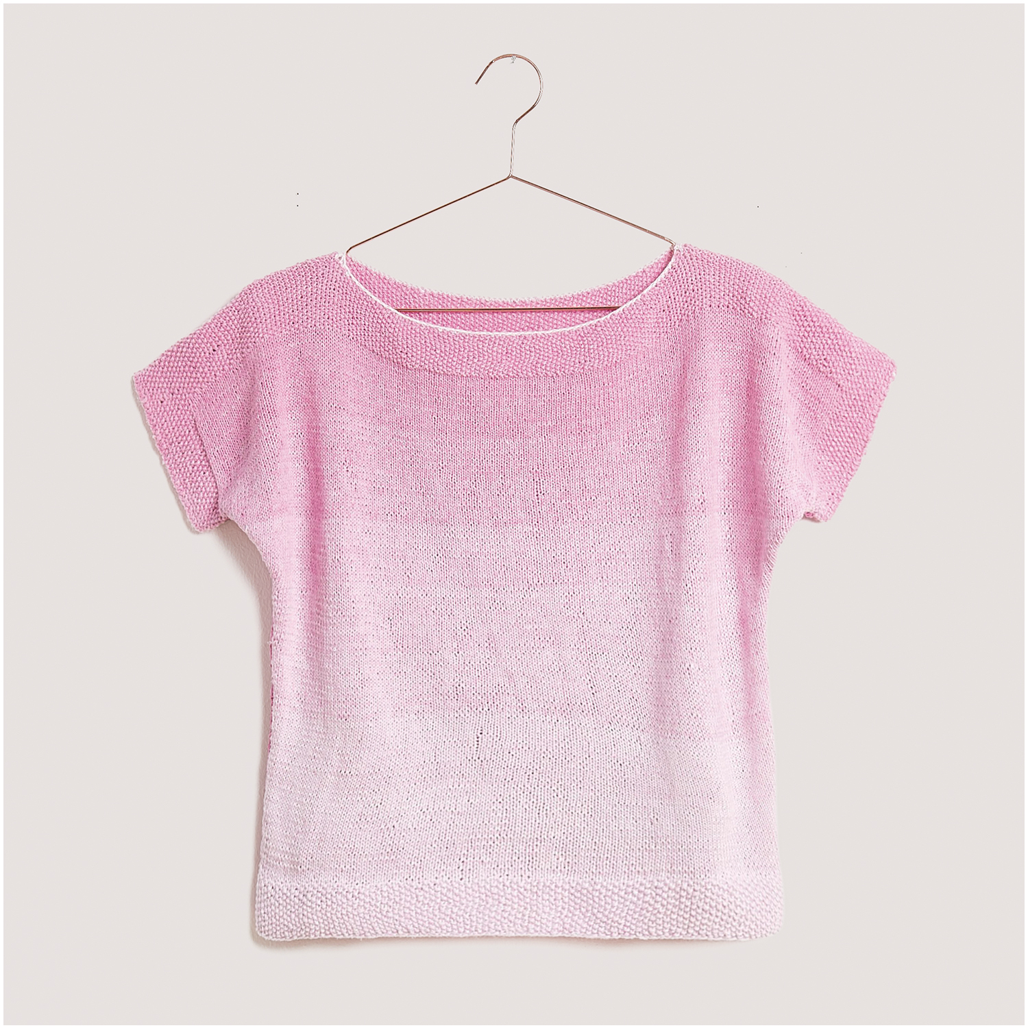 Strickset Shirt Modell 09 aus Lovewool Nr. 18, rosa Farbverlauf, kurzärmelig, auf einem Kleiderbügel hängend.