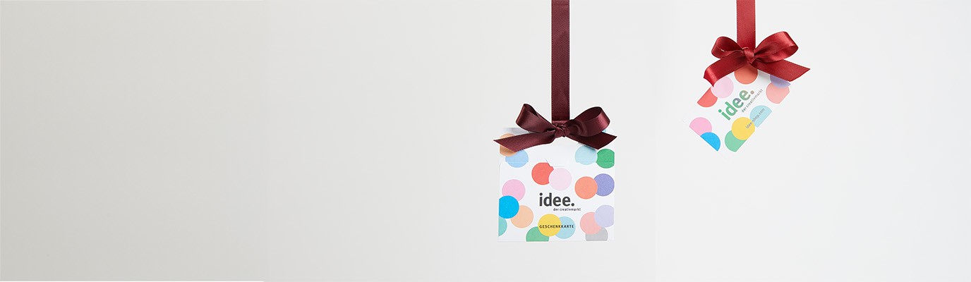 Zwei idee. Geschenkkarten hängen an roten Schleifenbändern in der Luft.
