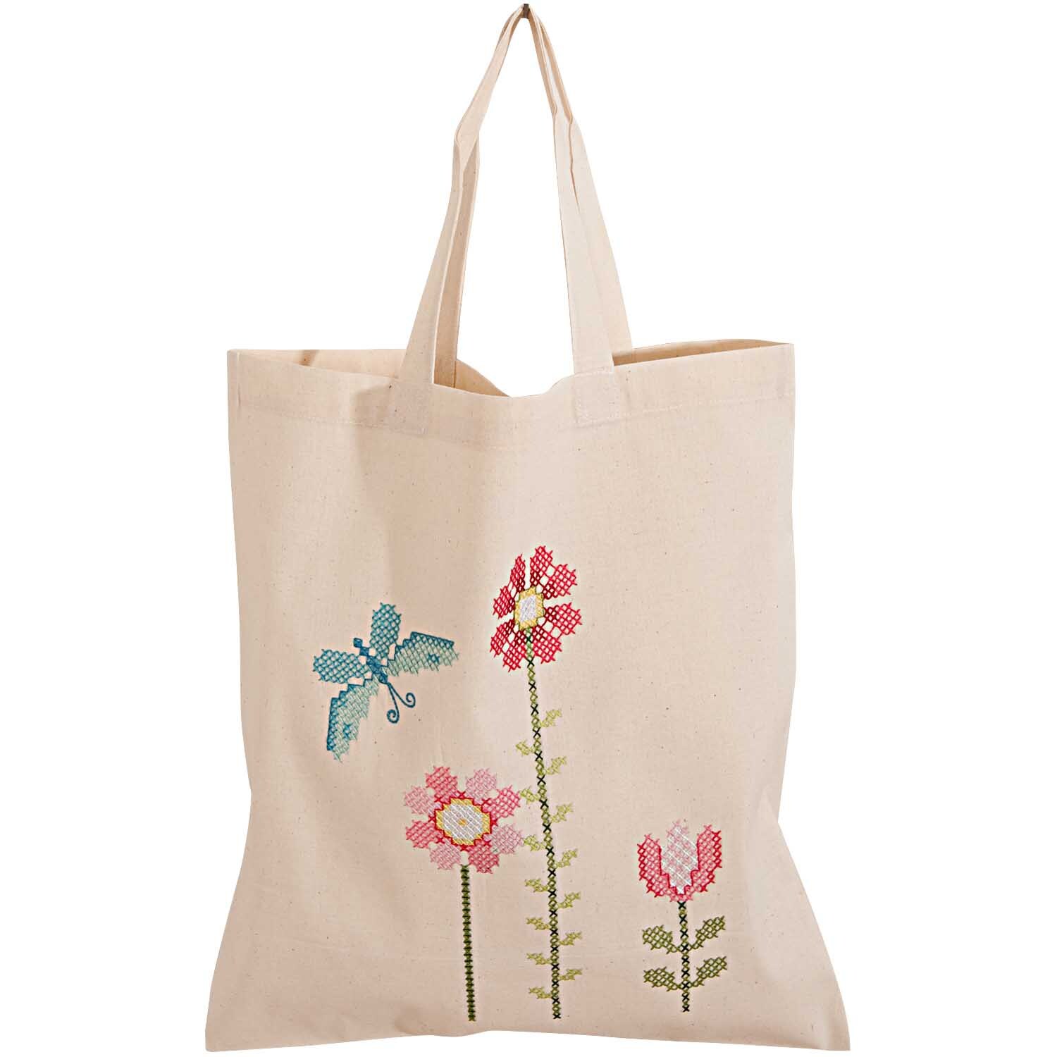 Stickpackung Tasche Blüten 38x45cm mit gestickten Blumen und Libelle auf beiger Stofftasche. Ideal für kreative Projekte.