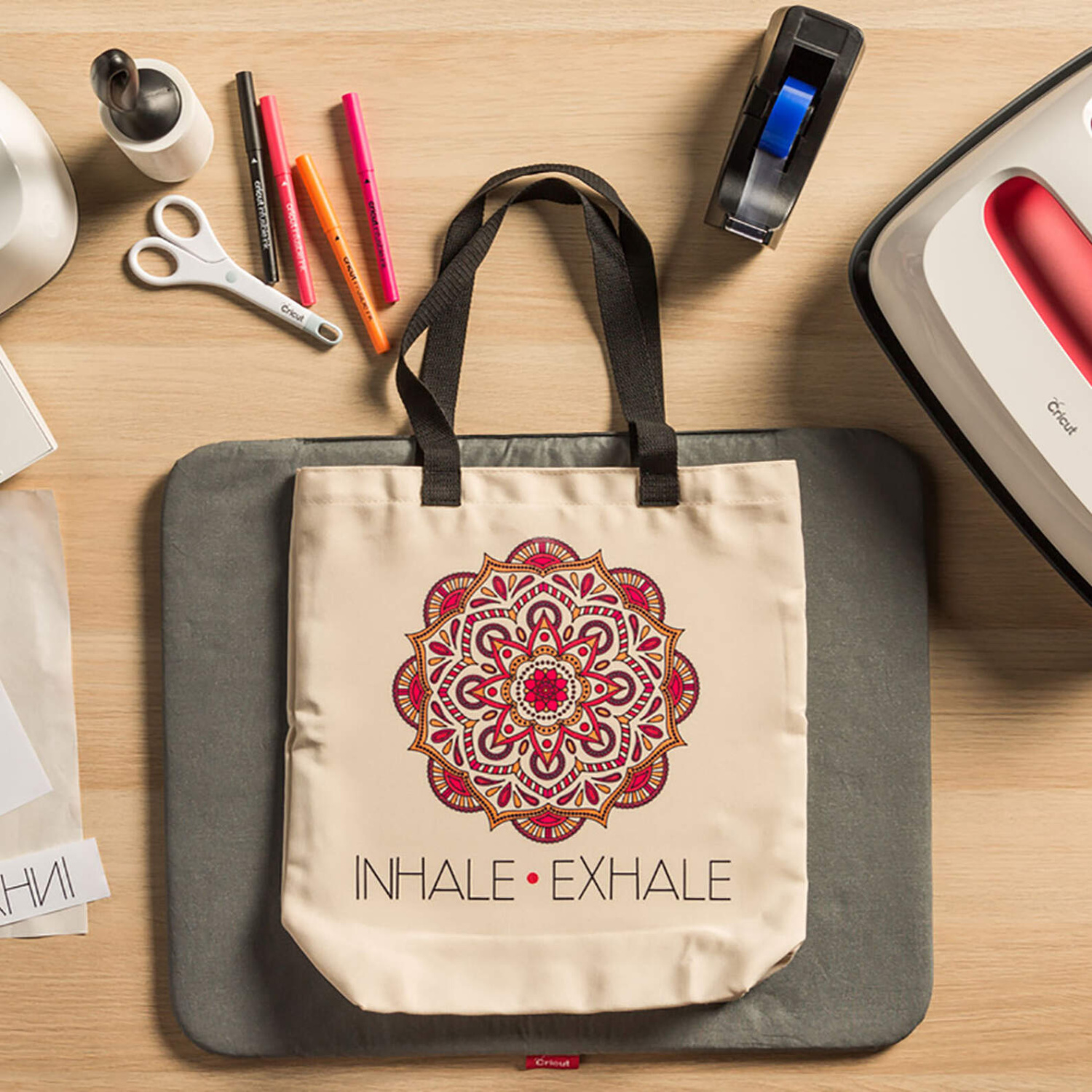 Infusible Ink™-Marker 1.0 Neon: Eine Tasche mit Mandala-Design, umgeben von Bastelwerkzeugen auf einem Tisch.