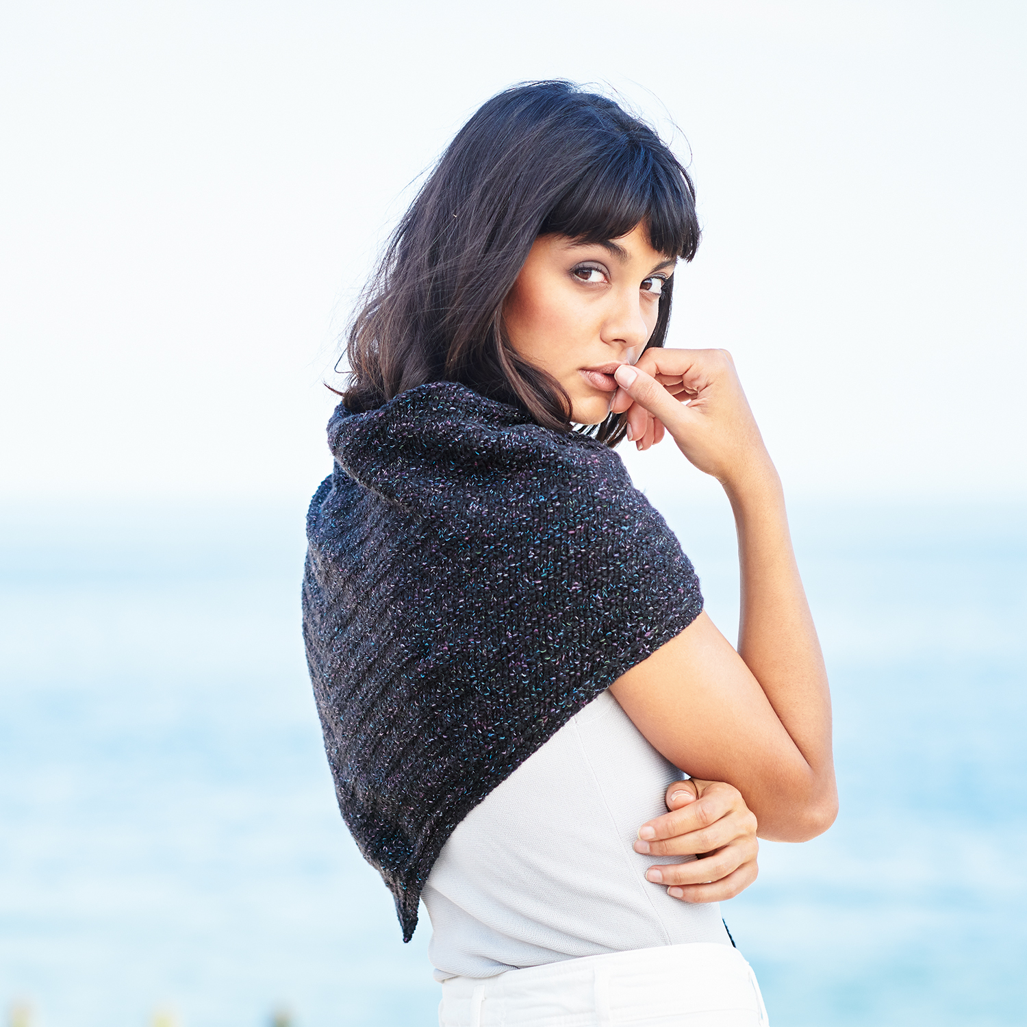 Strickanleitung Dreieckstuch aus Fashion Cottony: Frau am Meer mit dunklem Dreieckstuch.