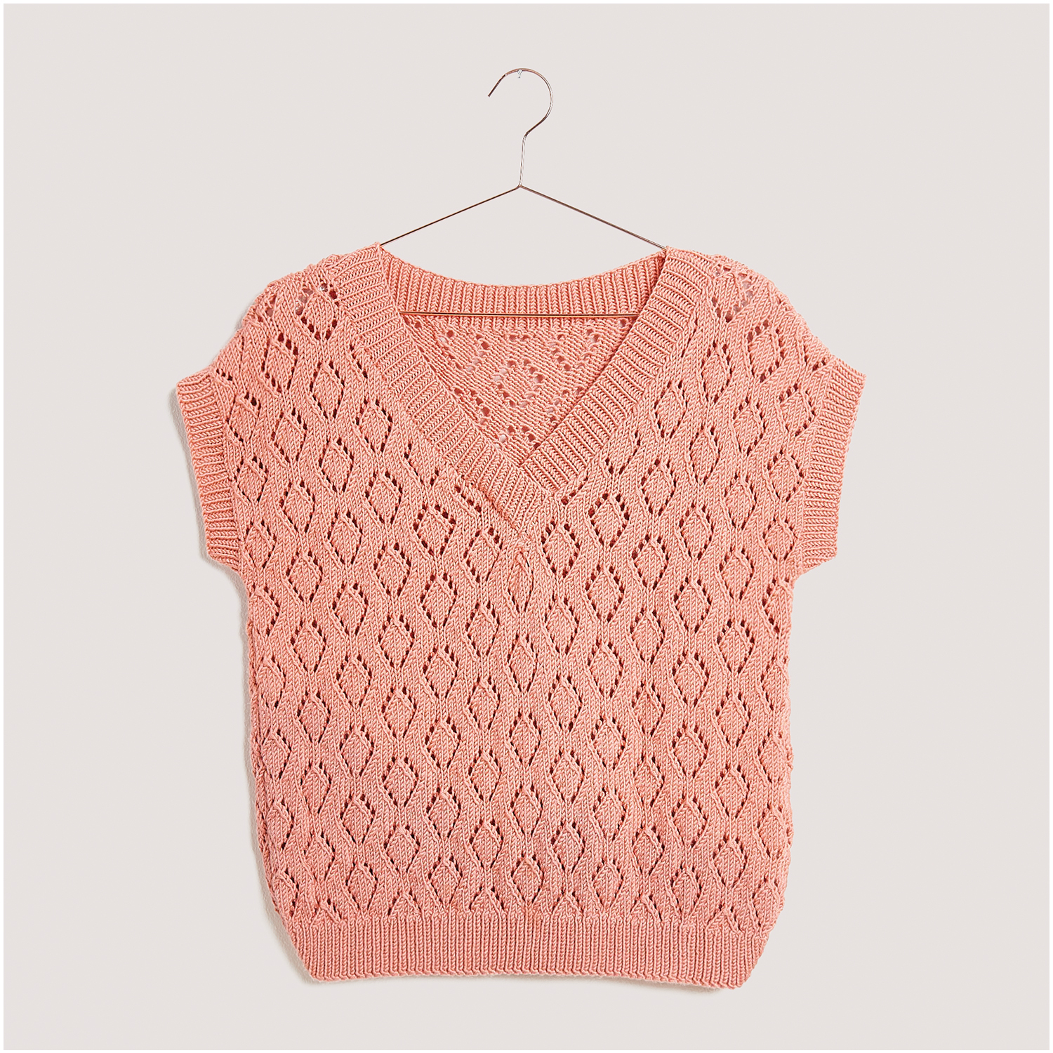 Strickset Pullunder Modell 05: Eleganter Pullunder in zartem Rosa mit V-Ausschnitt und Lochmuster. Ideal für stilvolle Strickprojekte.
