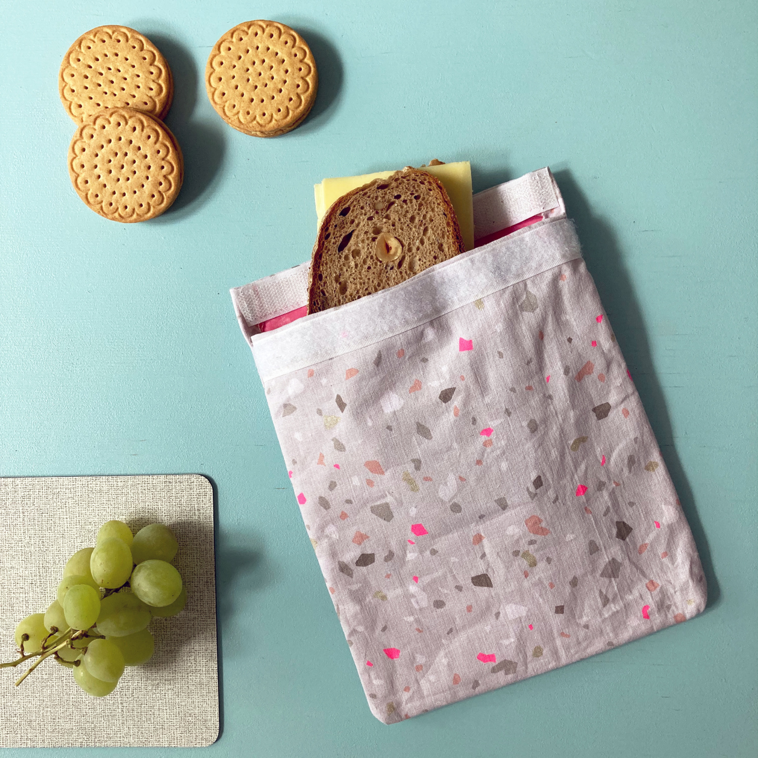 Nähanleitung Zero Waste Brotbeutel: Ein wiederverwendbarer Stoffbeutel mit Brot und Keksen auf einem Tisch.