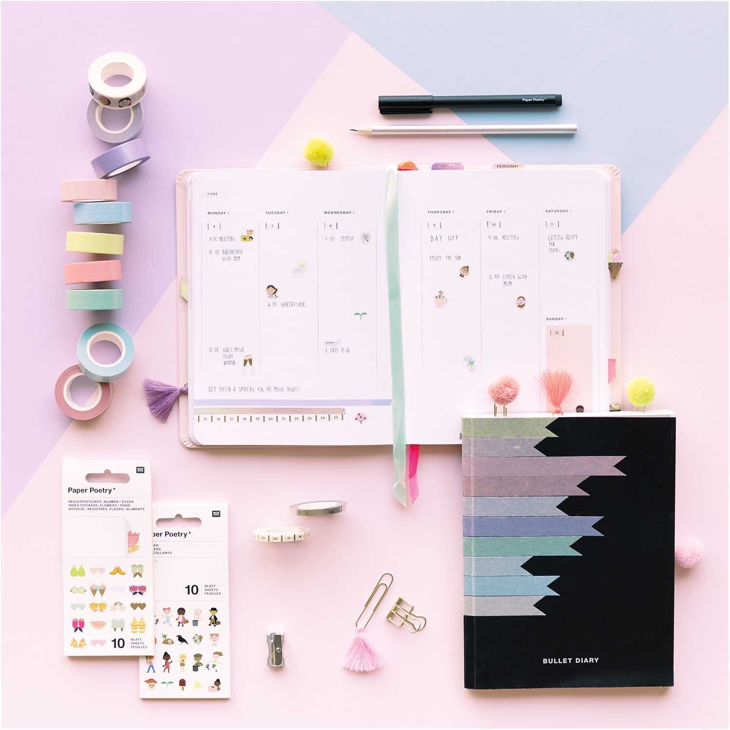 Paper Poetry Tape Set pastell 15mm 5m 10 Stück, mehrfarbig, neben einem geöffneten Planer und Bullet Journal auf rosa Hintergrund.