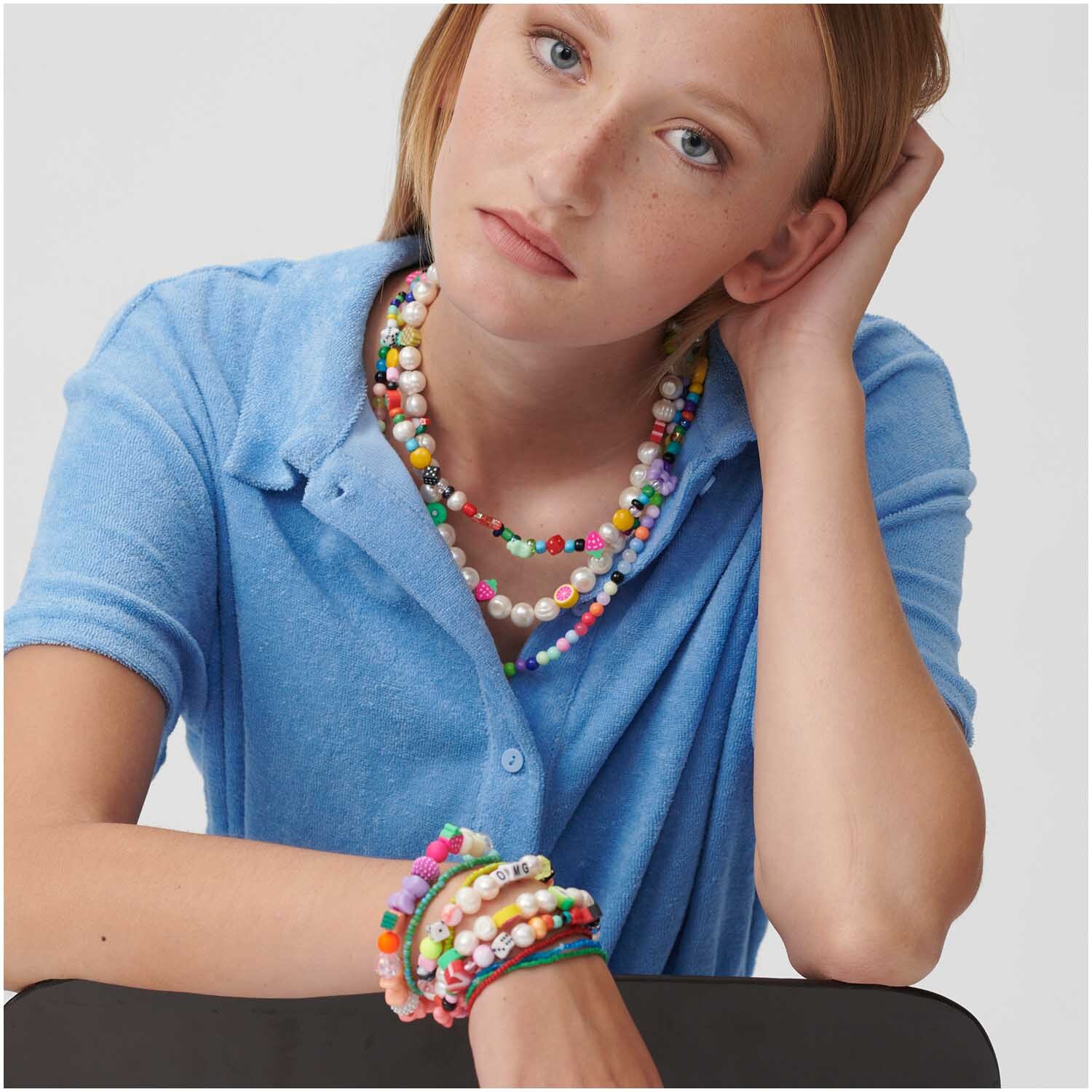 itoshii Perlen Würfel 6mm 96 Stück, getragen als bunte Halsketten und Armbänder von einer Frau in blauem Hemd. Ideal für kreative Designs.