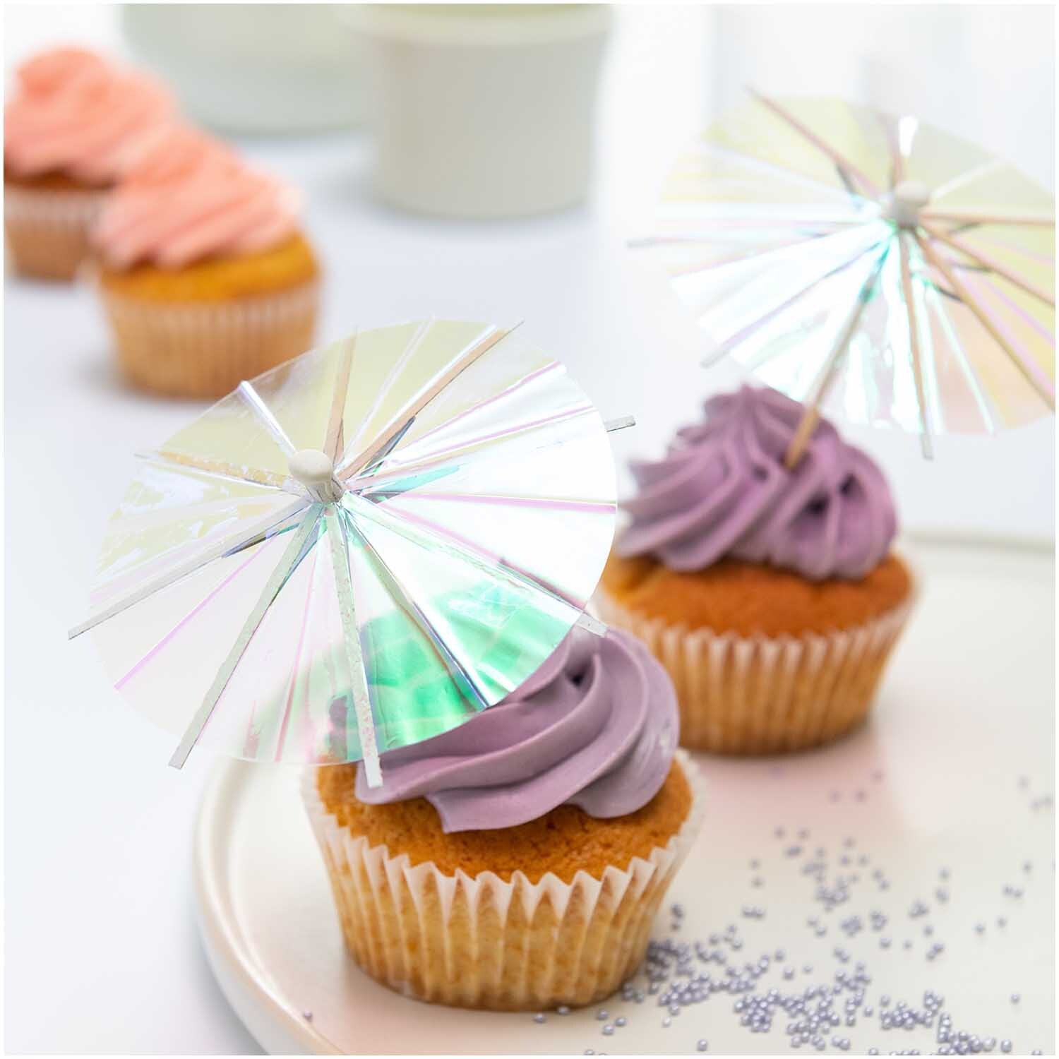 Picker Schirmchen irisierend 8,3cm 12 Stück von Rico Design auf Cupcakes mit lila Zuckerguss dekoriert.