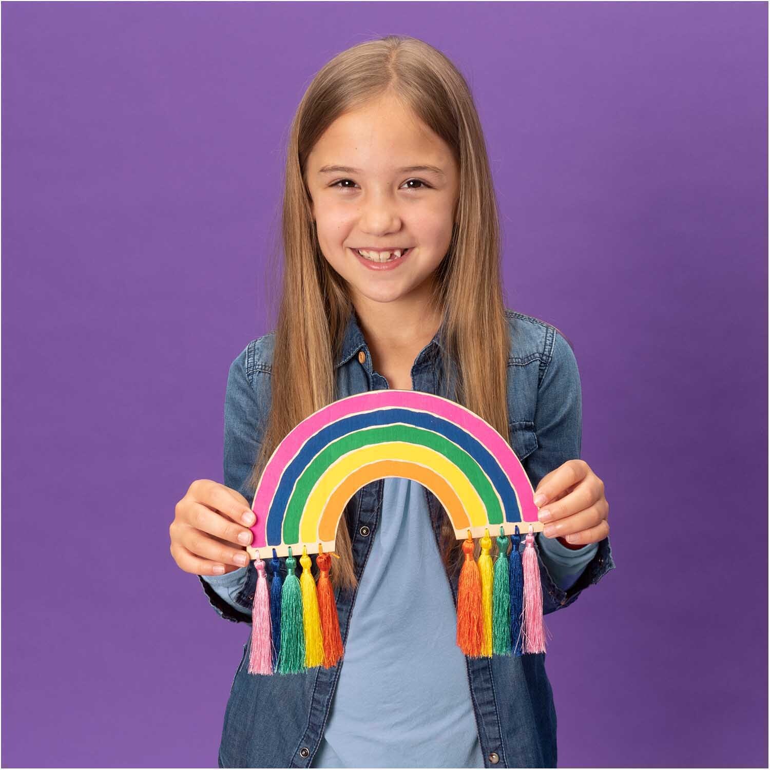 Quasten fein 9cm 5 Stück: Ein Mädchen hält einen bunten Regenbogen mit Quasten von Rico Design.
