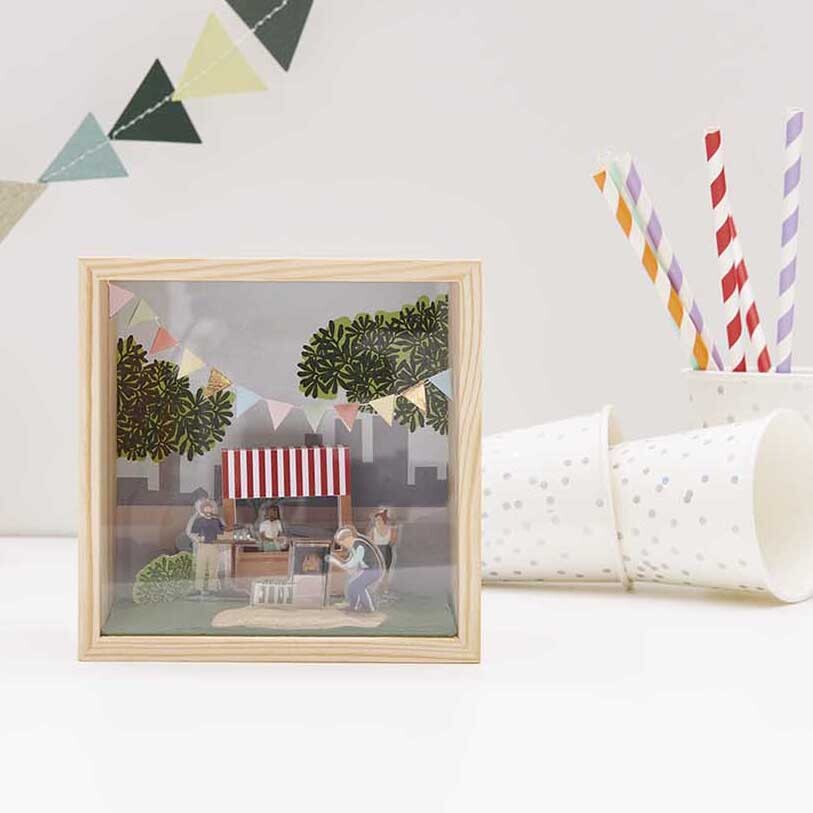 Figurico Gelsticker Gartenparty: Bunte Szene mit Marktstand und Girlanden in Holzrahmen, ideal für kreative Dekorationen.