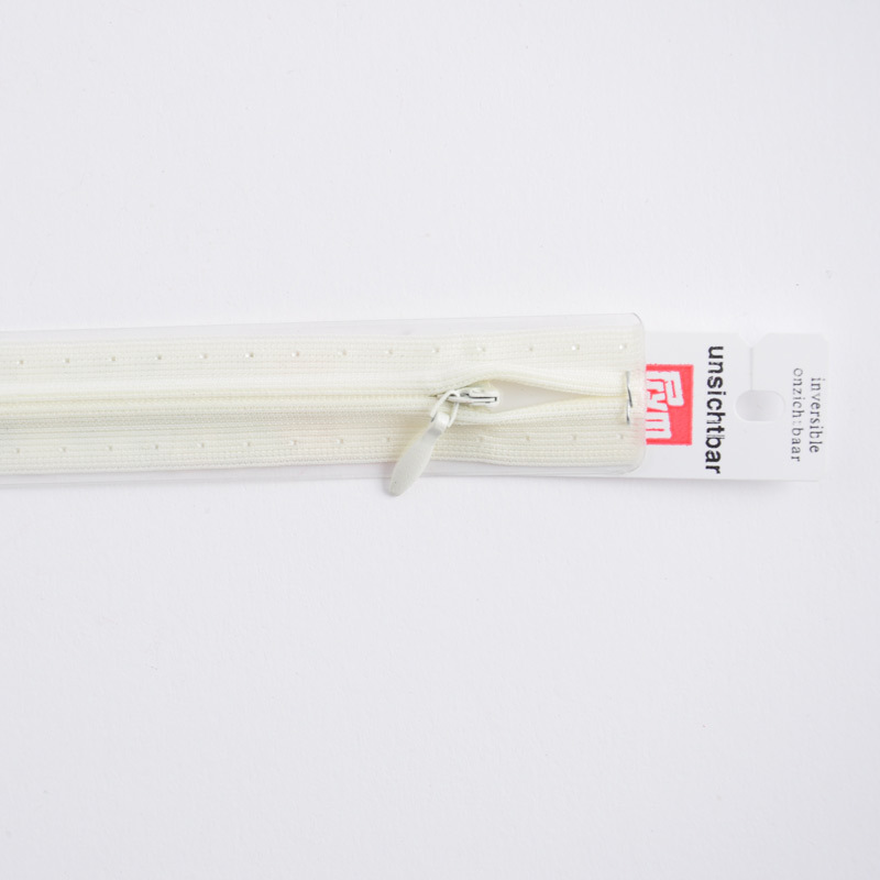 Reißverschluss S6 unsichtbar creme 22cm von Prym, zeigt einen cremefarbenen, unsichtbaren Reißverschluss mit Etikett.