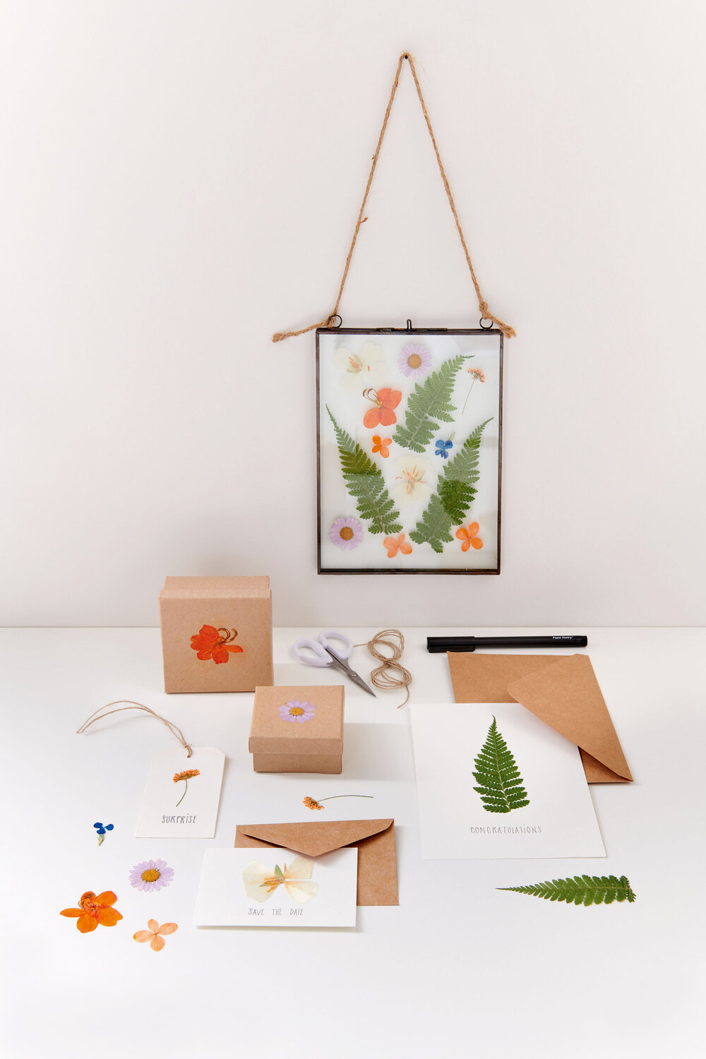 Gepresste Blüten Mix Set in Rahmen, violett-orange, 13 Stück von Rico Design auf Regal.