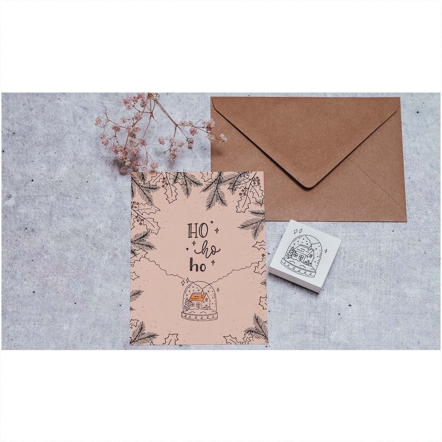 Stempel Schneekugel weiß 45x45mm von May&Berry neben einer Karte mit Umschlag auf grauem Hintergrund.