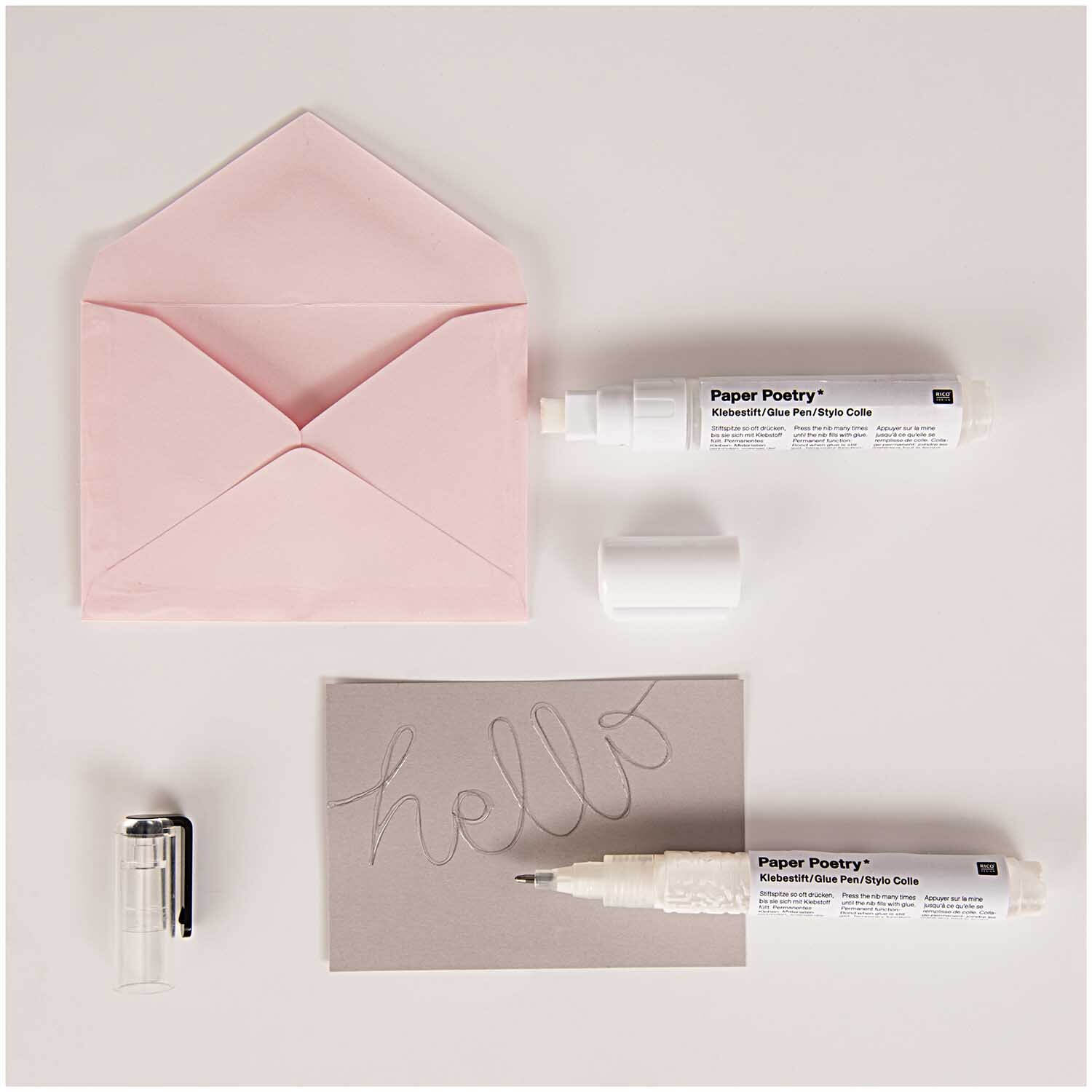 Paper Poetry Klebestift für Transferfolie 4mm, ideal für kreative Projekte, neben rosa Umschlag und grauer Karte mit "hello".