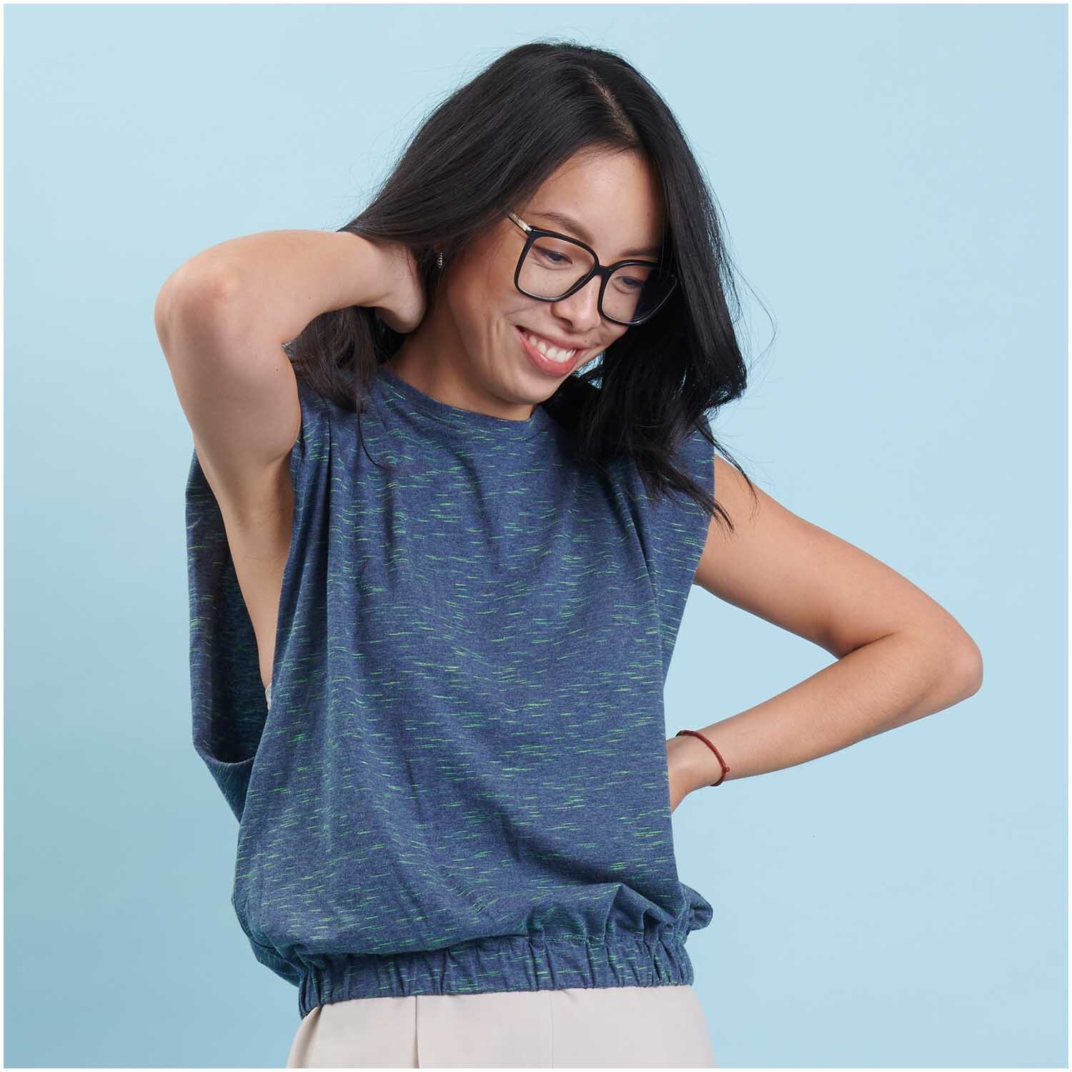 Meterware Jersey dunkel blau/neon grün von Rico Design: Frau in ärmellosem Oberteil vor blauem Hintergrund.
