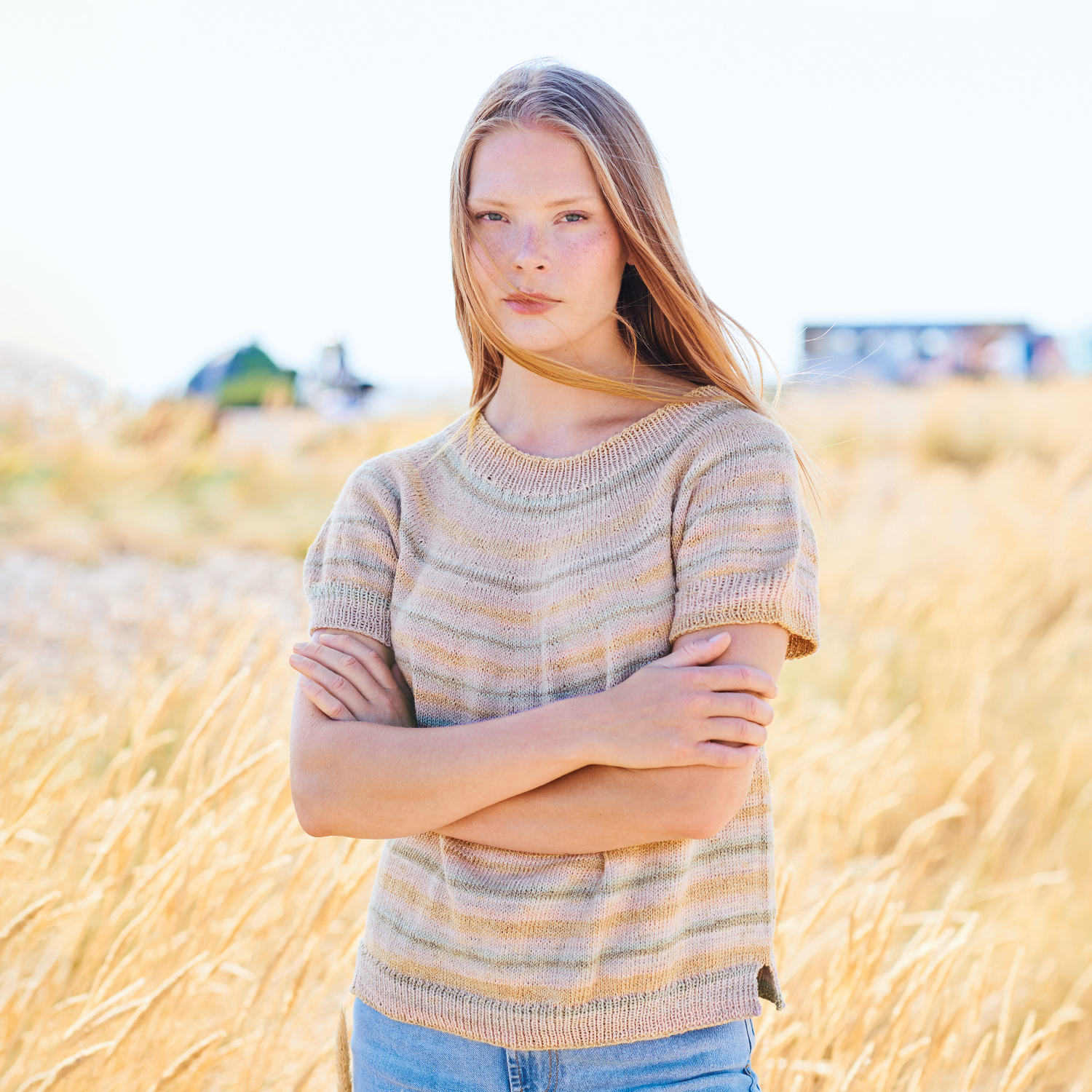 Strickanleitung Shirt aus Creative Cotton Camouflage: Frau im gestreiften Shirt in Feldlandschaft.