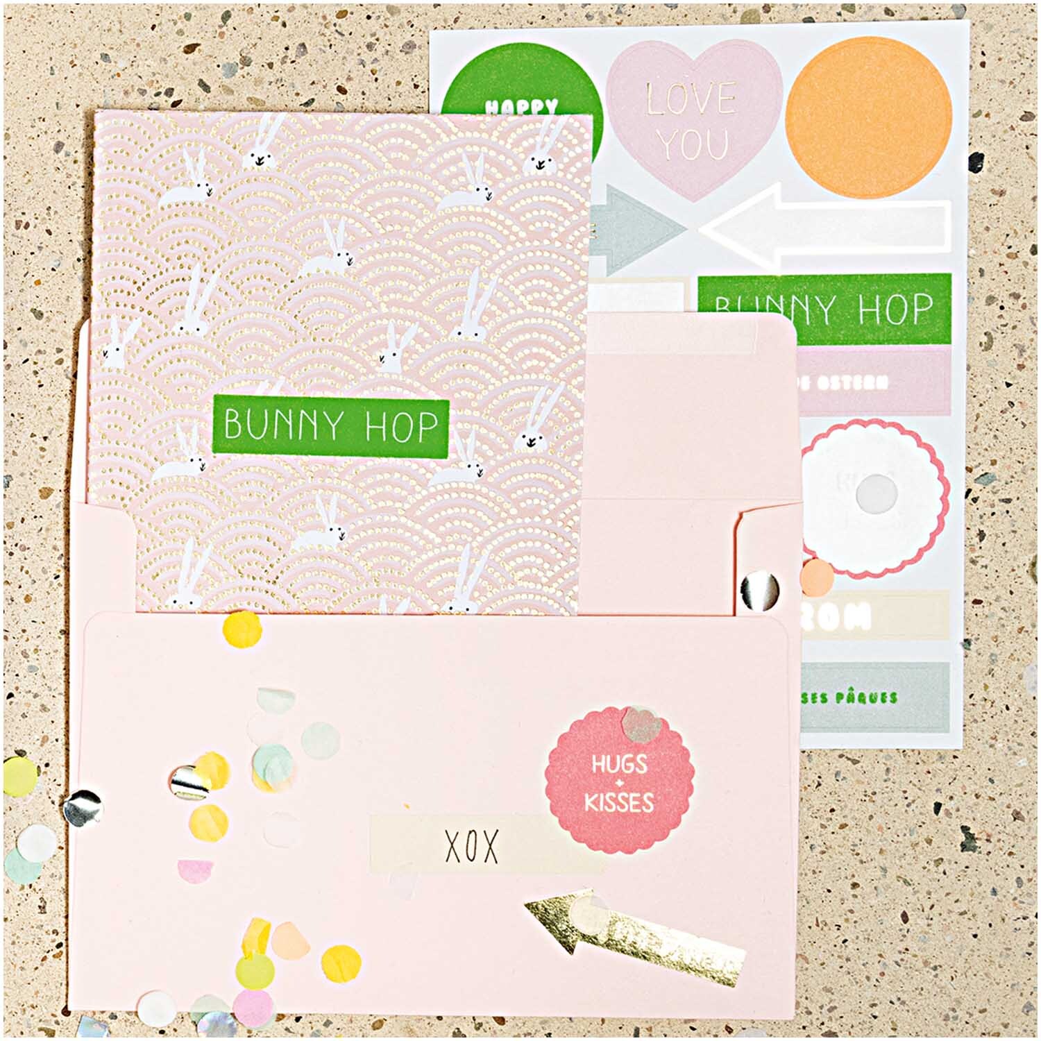 Paper Poetry Grußkartenset Bunny Hop zeigt Hasen im Feld mit pastellfarbenen Karten und Umschlägen. Markenname: Rico Design.