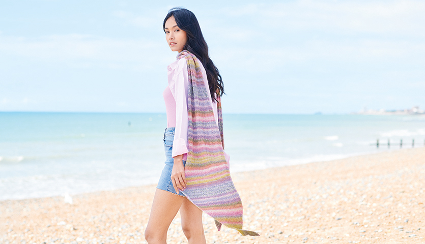 Strickanleitung Tuch aus Fashion Cotton Merino Lace: Frau am Strand mit buntem Tuch.