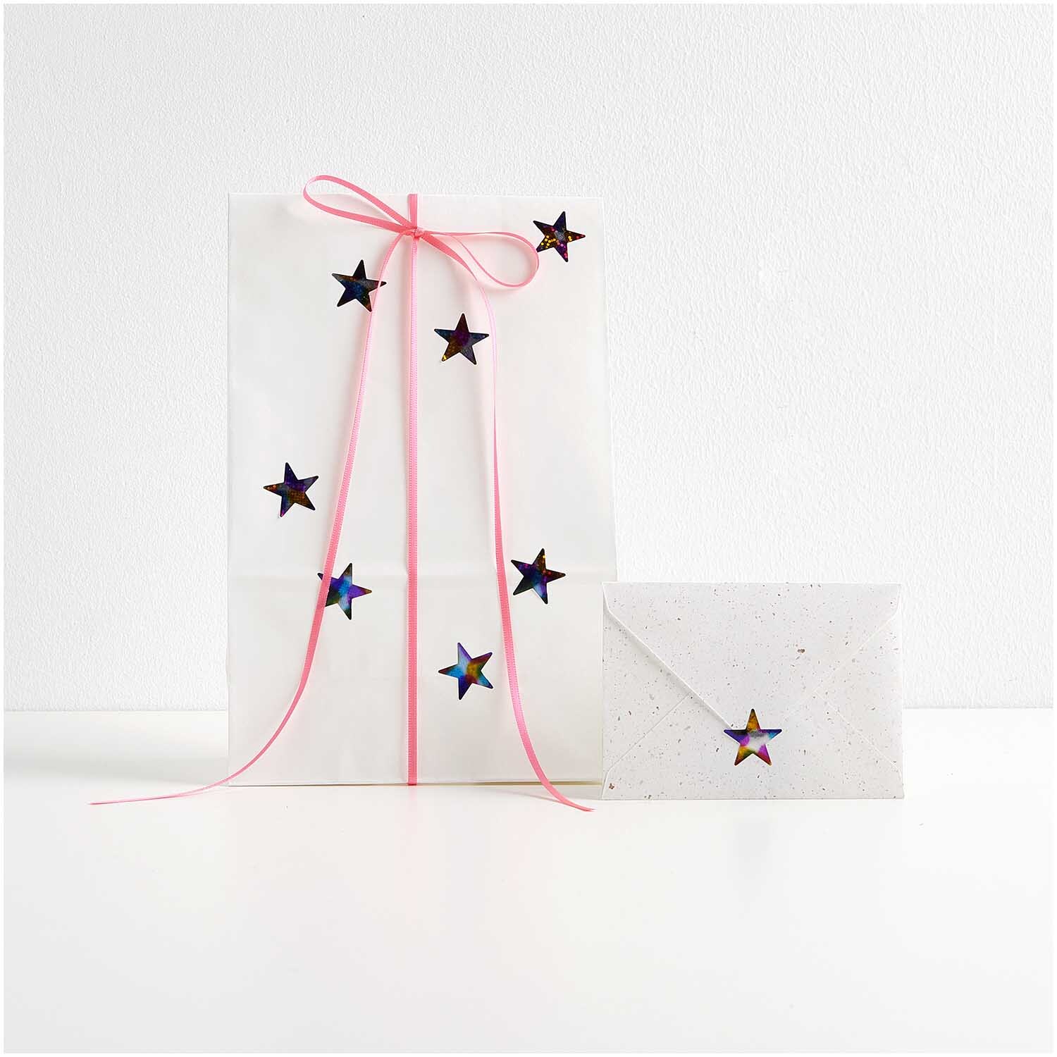 Paper Poetry Mini-Sticker Sterne Rainbow auf der Rolle: Geschenkverpackung mit bunten Sternstickern und rosa Schleife, 120 Stück von Rico Design.