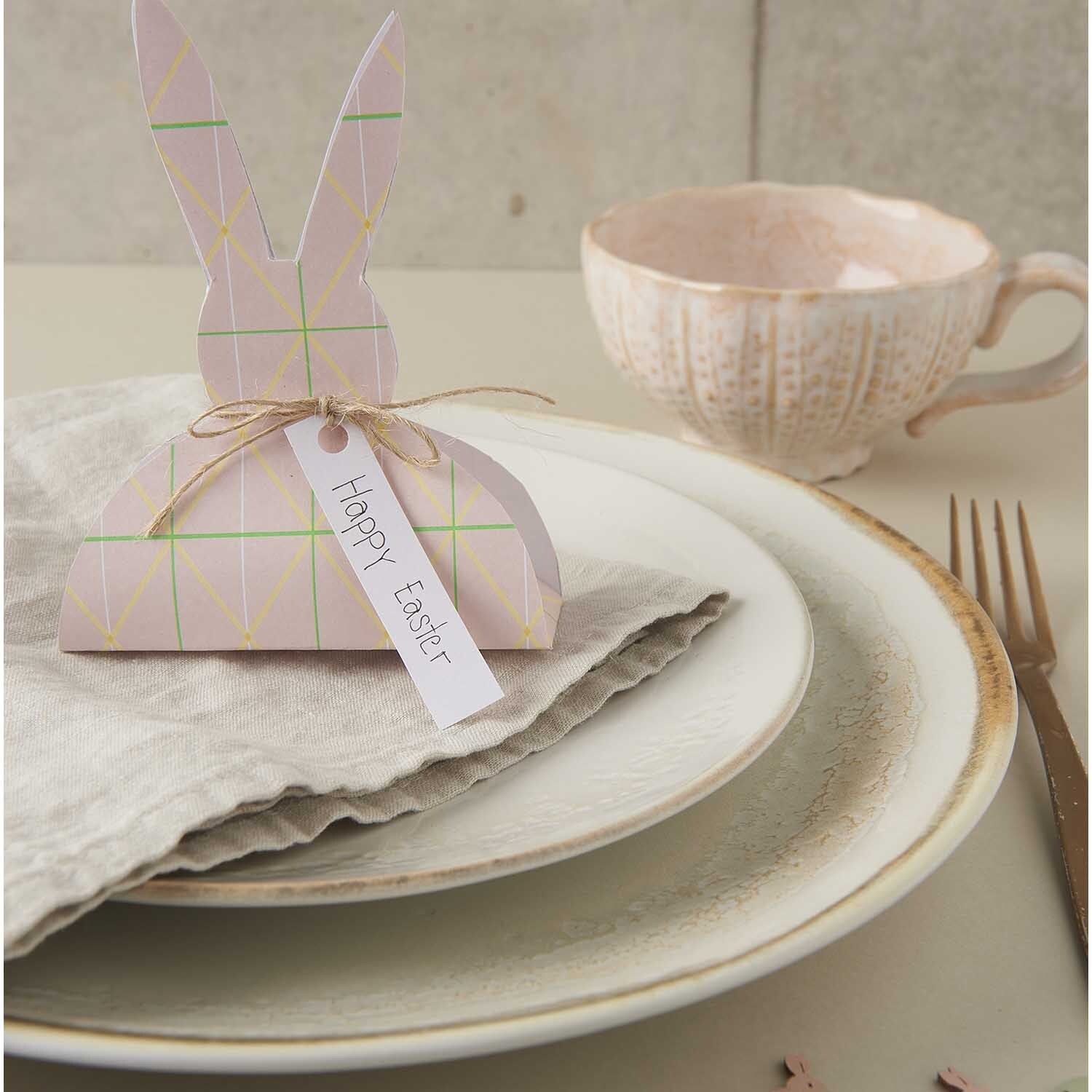 Paper Poetry Motivkarton Bunny Hop zeigt einen dekorativen Tisch mit Osterhasen-Dekoration und Geschirr. Ideal für festliche Anlässe.