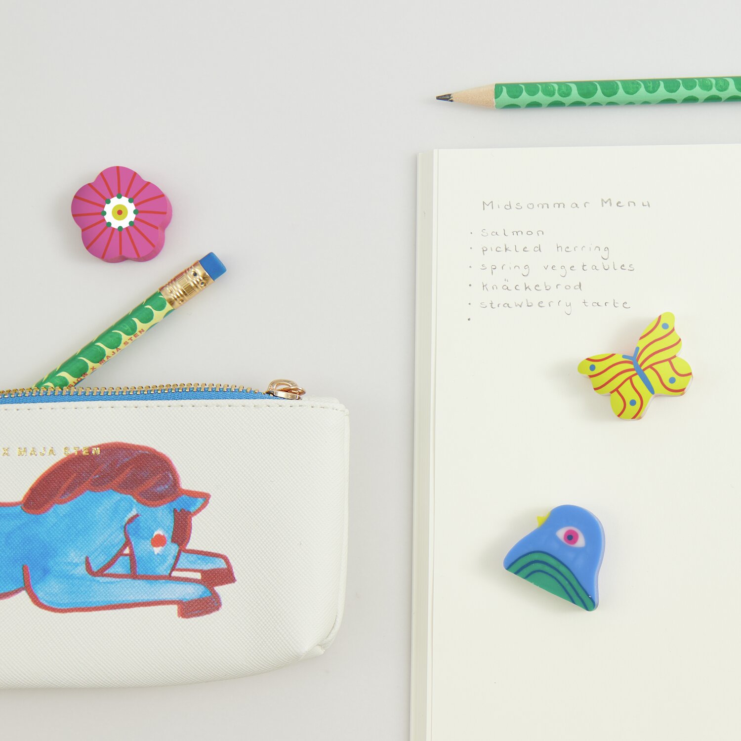 Radiergummis Midsommar Magic 3x3cm, bunt, auf Schreibtisch mit Notizbuch, Stiften und Etui.