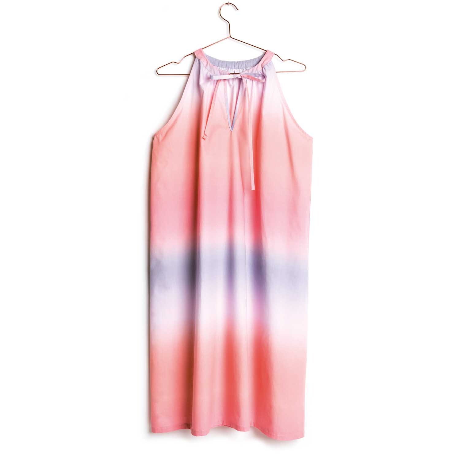 Druckstoff Crafted Nature zeigt ein Kleid mit rosa Farbverlauf von Rico Design, hängend an einem Bügel.