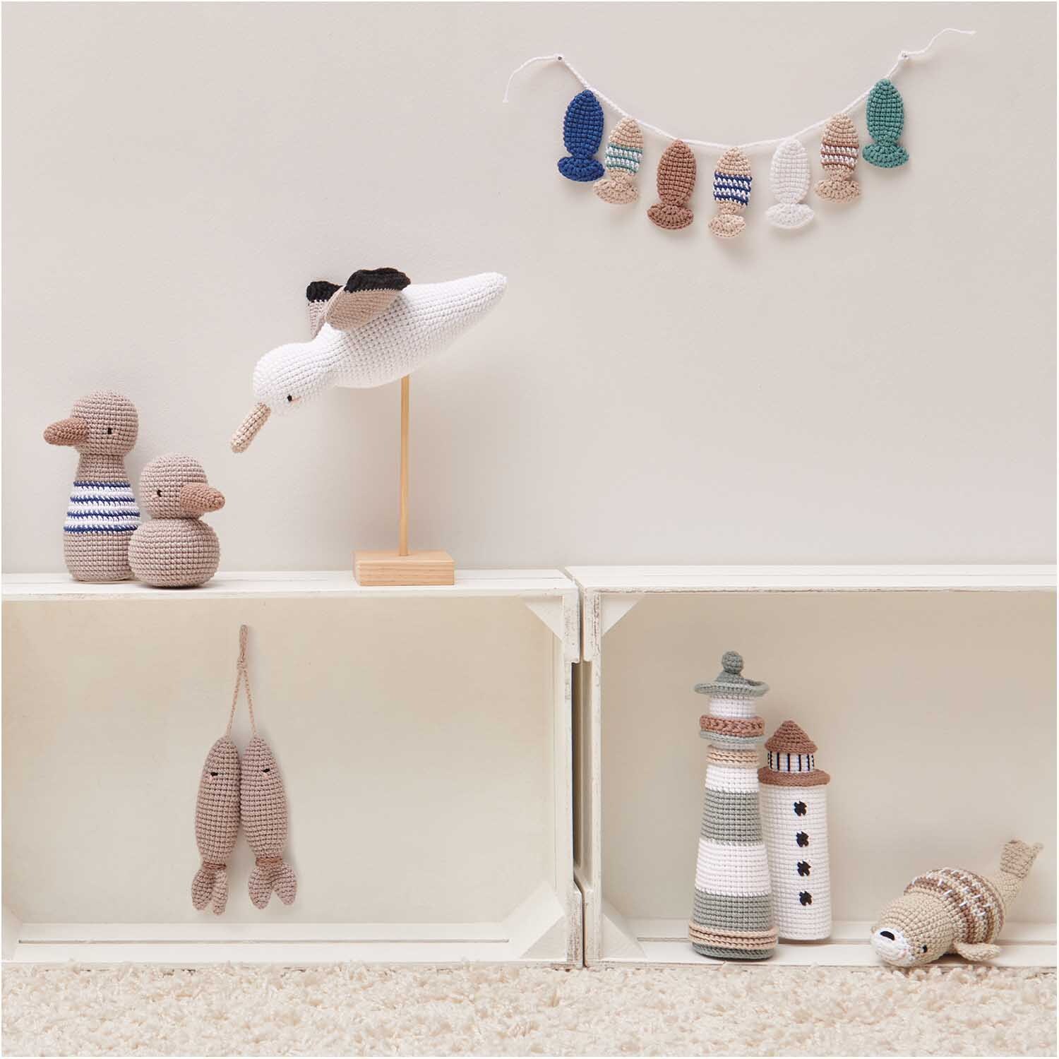 Creative Ricorumi dk: Handgefertigte Häkeltiere und Dekorationen in neutralen Tönen auf weißen Regalen.
