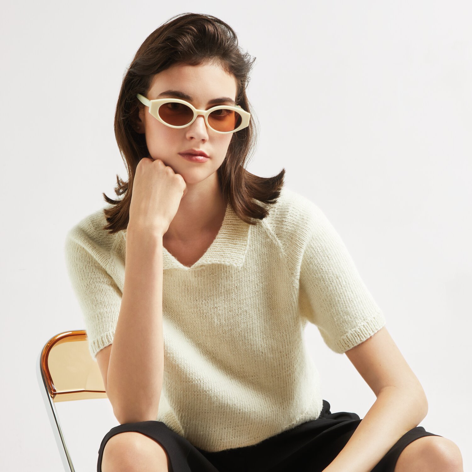 Made by Me No. 20 Frühjahr-Sommer: Frau in offwhite Strickpullover, sitzt auf Stuhl, trägt Sonnenbrille.