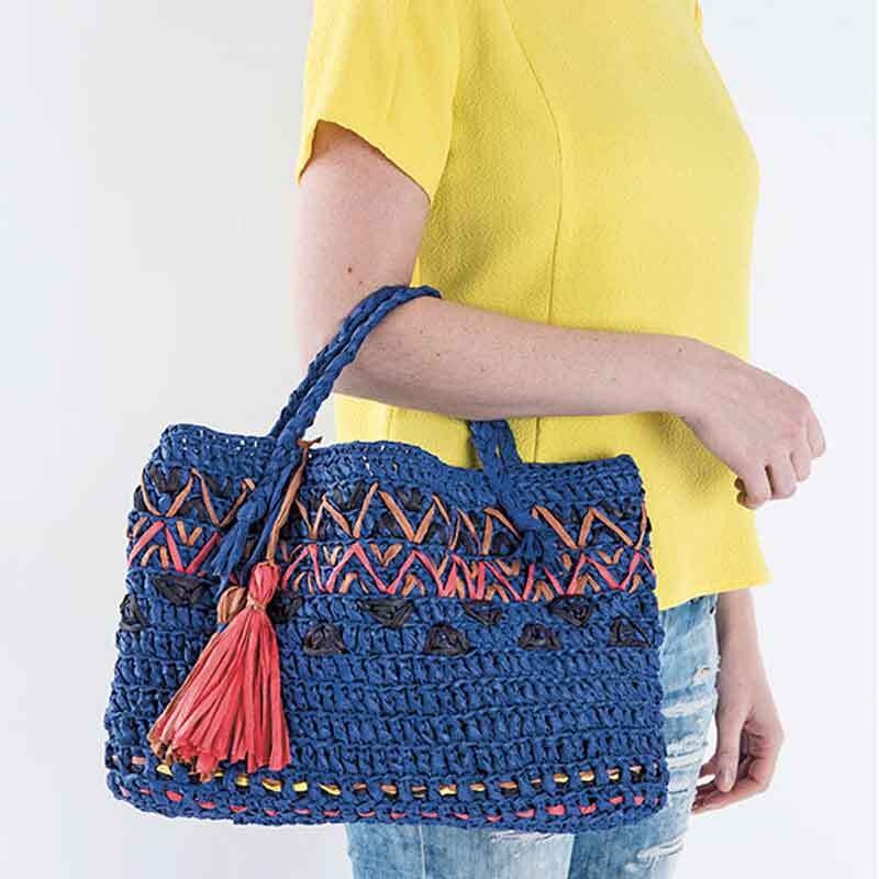 Creative Paper: Frau trägt eine blaue, gehäkelte Tasche mit roten Akzenten von Rico Design.