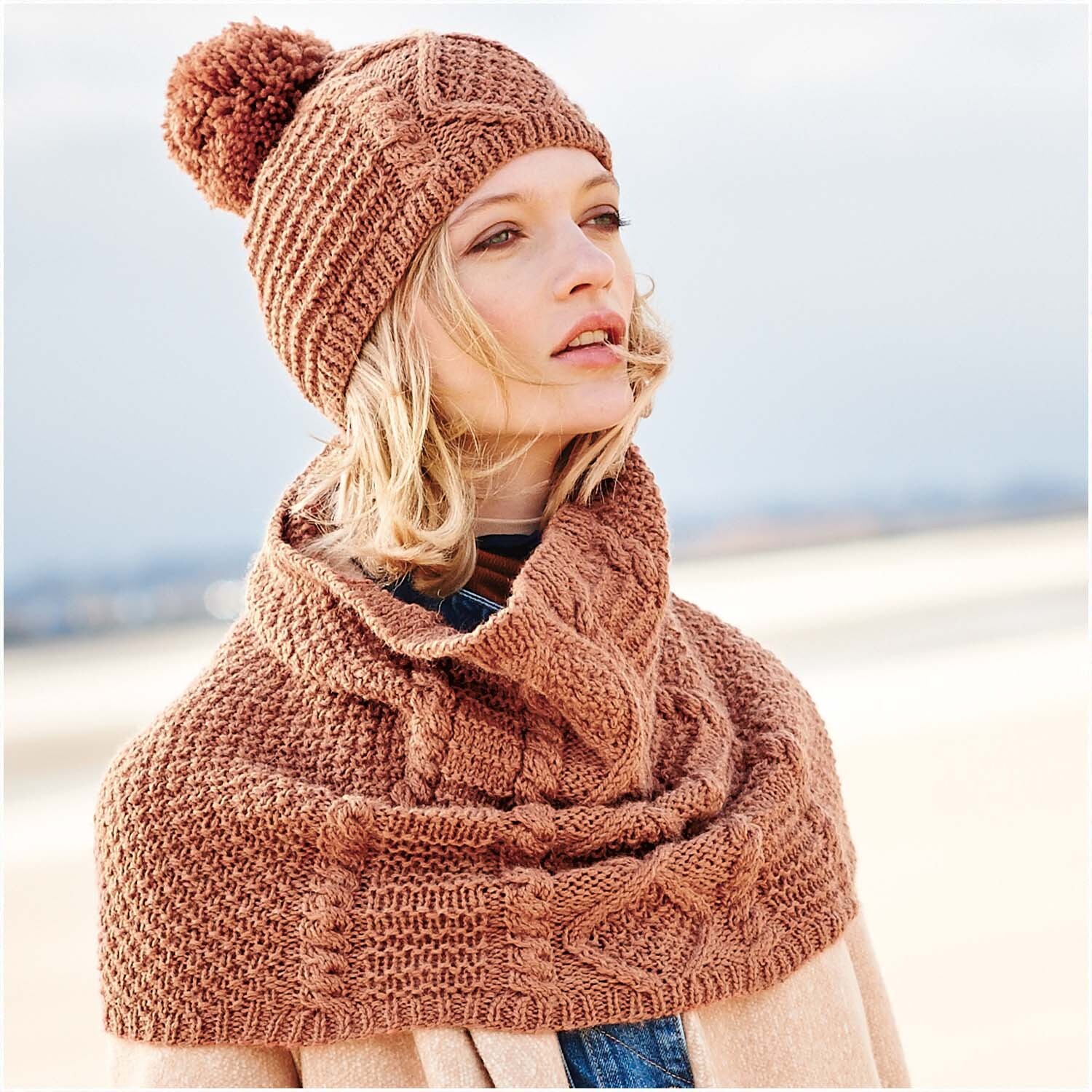 Creative Soft Wool aran: Frau trägt gestrickte Mütze und Schal in Nougat, ideal für kalte Tage.