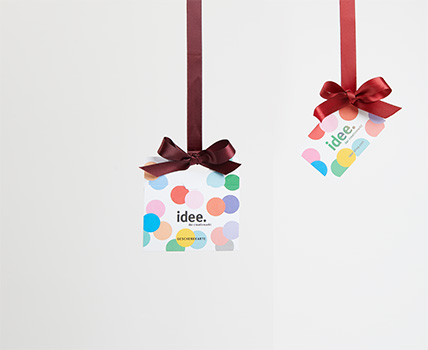 Zwei idee. Geschenkkarten hängen an roten Schleifenbändern in der Luft.