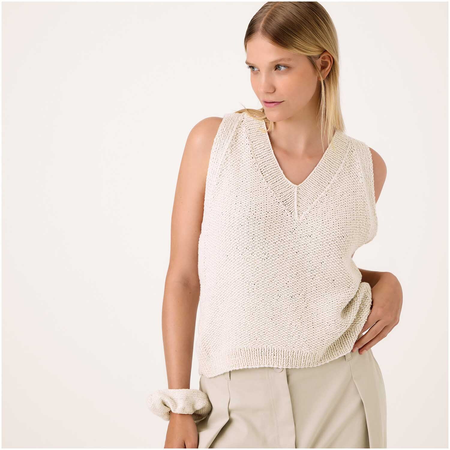 Luxury Organic Cotton Silk dk: Frau trägt cremefarbenen ärmellosen Strickpullover von Rico Design.