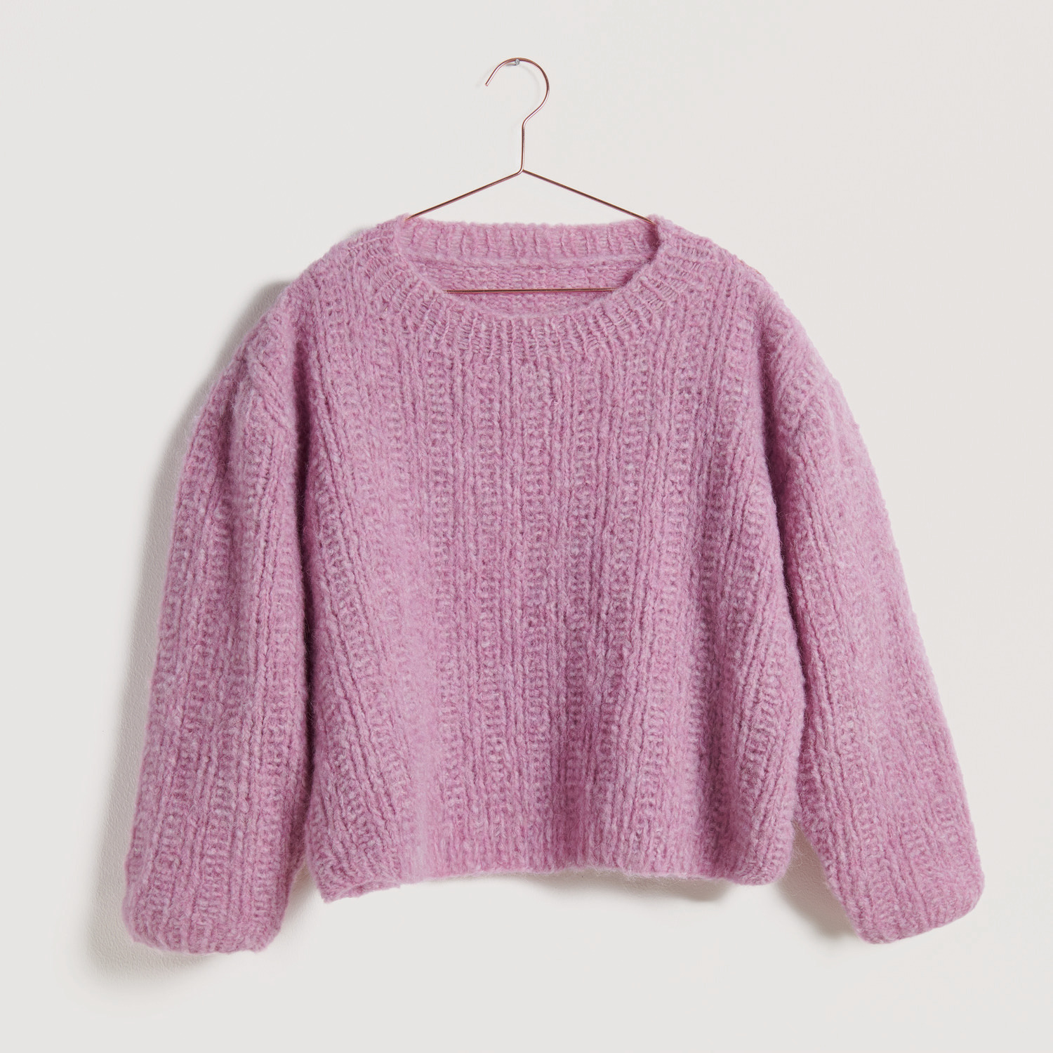 Pinker Pullover auf grauem Hintergrund – zum Strickset