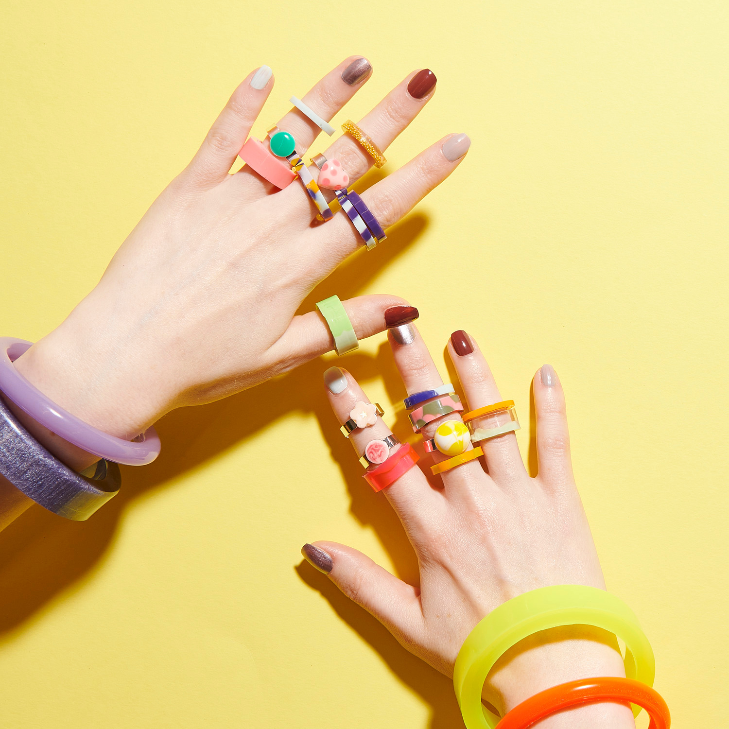 Silikon Gießform Armreif: Hände mit bunten Ringen und Armreifen auf gelbem Hintergrund, Marke Rico Design.