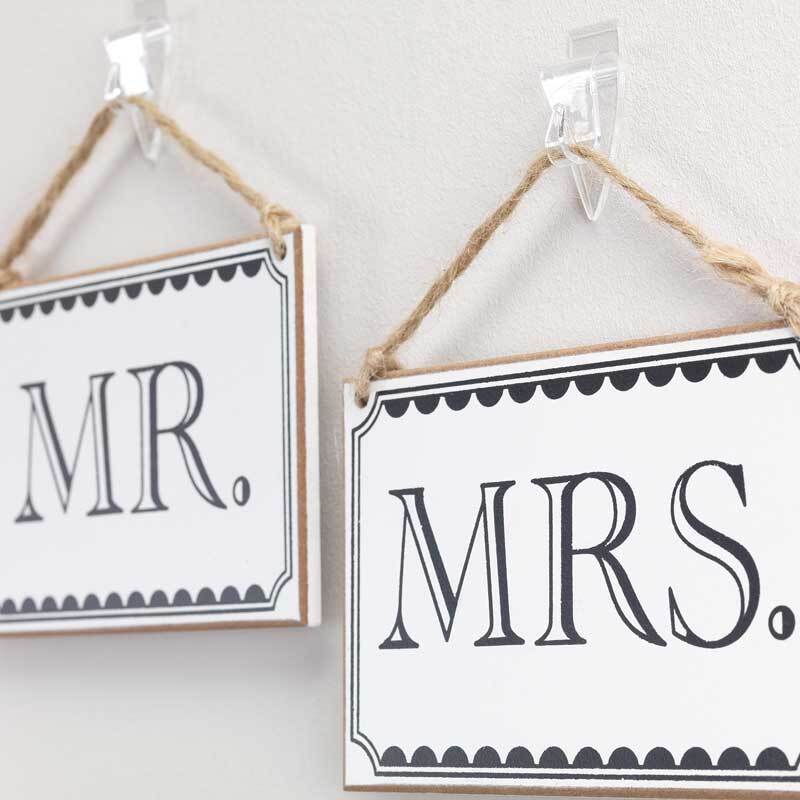 Powerstrips Decohaken kristallklar von tesa halten Schilder mit der Aufschrift "MR." und "MRS." an der Wand.