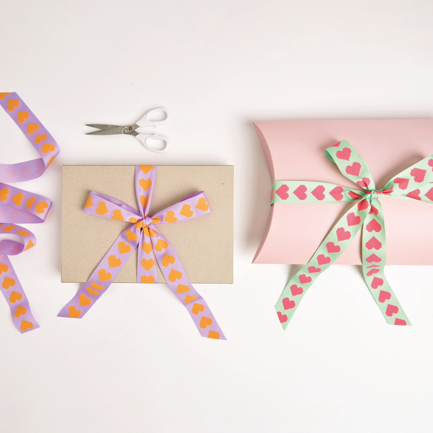 Paper Poetry Taftband Pixel Herzen verziert Geschenke in Flieder/Neon Orange und Mint/Neon Pink.