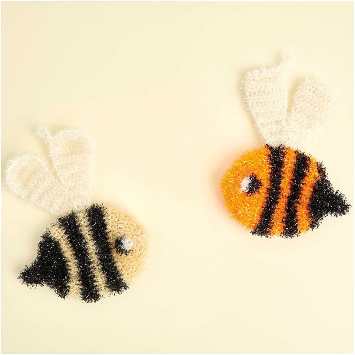 Creative Bubble: Zwei gestrickte Bienen aus Rico Design Garn, eine in Schwarz, die andere in Orange.