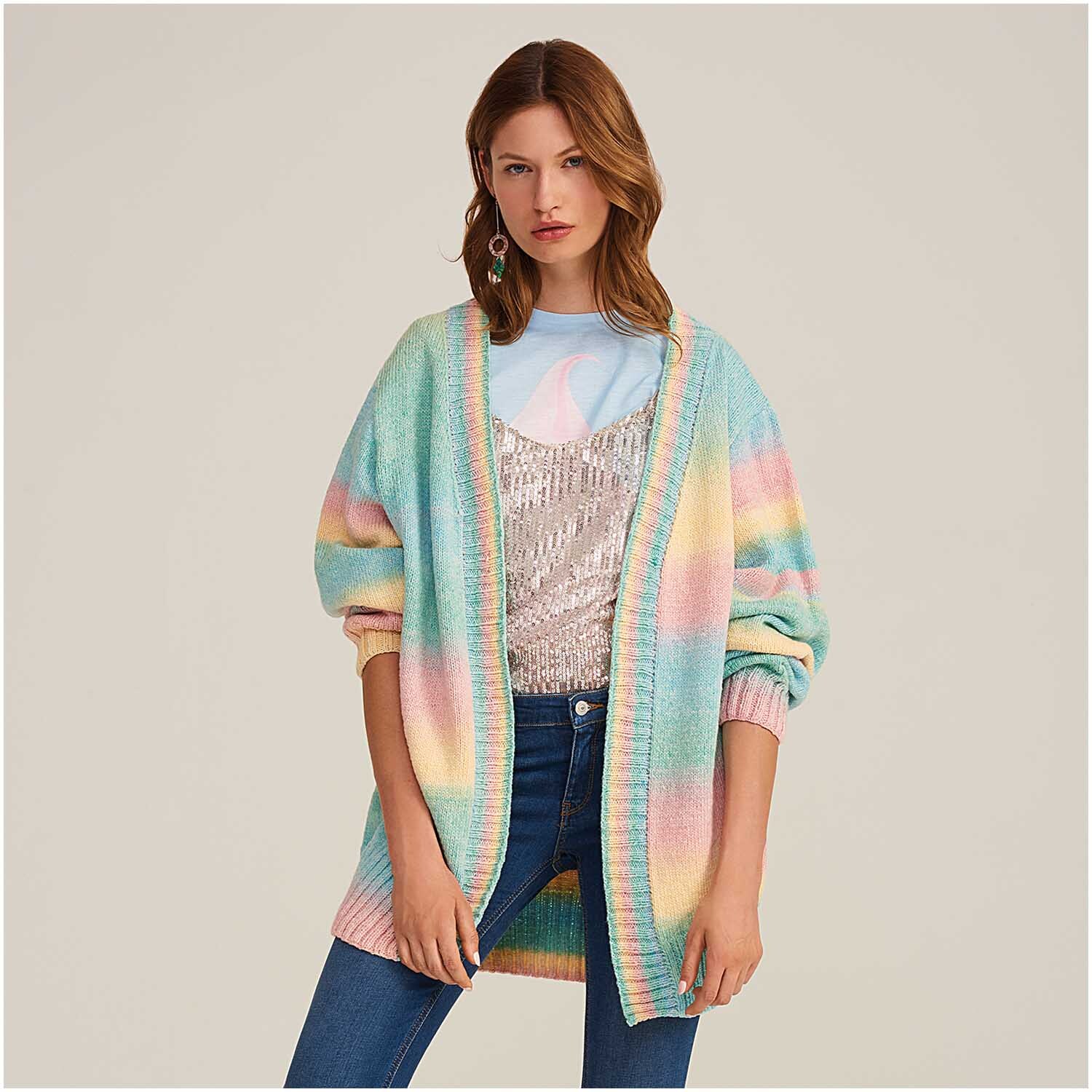 Fashion Cotton Light & Long dk: Frau trägt einen bunten Strickcardigan von Rico Design über einem glitzernden Top.