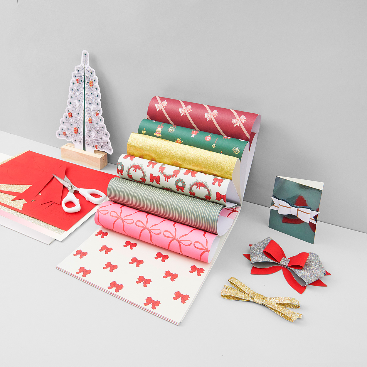 Weihnachtliches Bastelpapier aufgefächert und Papier schleifen. Fotosetting graue Ecke.
