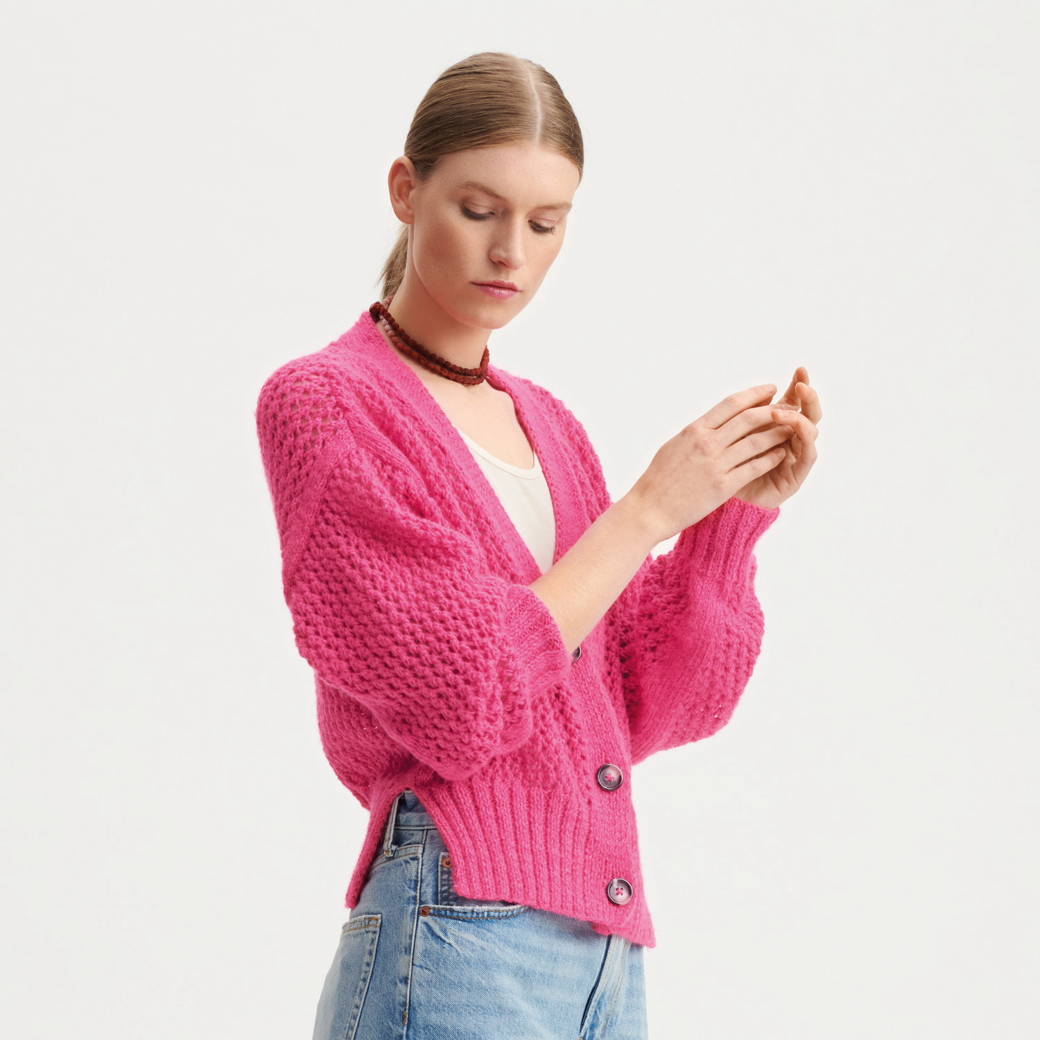 Creative Fluffily dk Strickset Jacke Modell 14 in leuchtendem Pink, getragen von einer Frau.