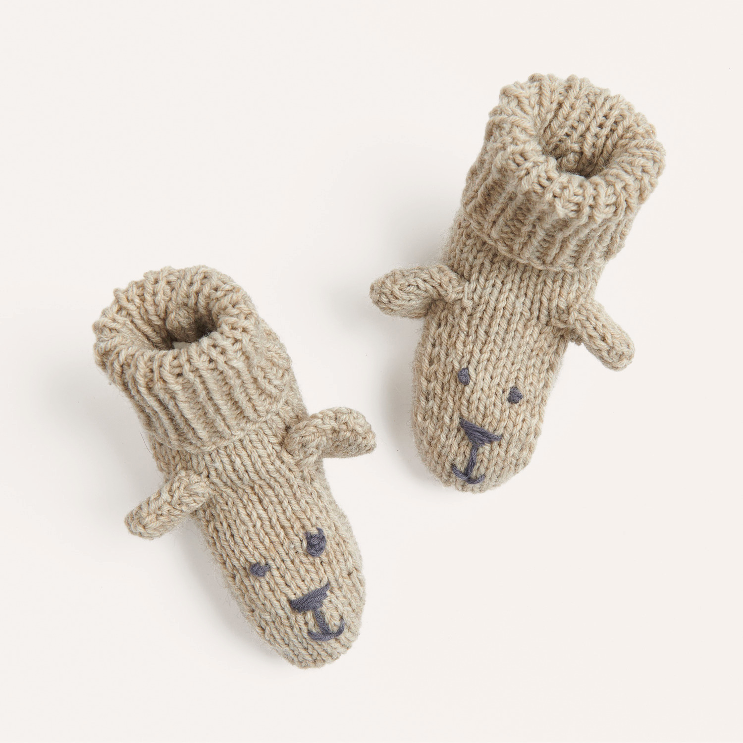 Strickset Schühchen mit Teddyohren Modell 16 aus Rico Baby 040: Beigefarbene Babyschuhe mit niedlichen Ohren und Gesichtsstickerei.
