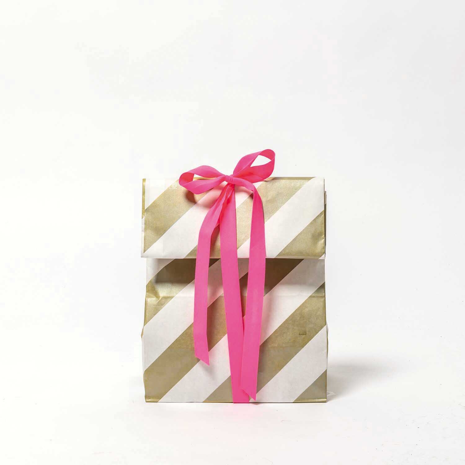 Paper Poetry Ripsband 16mm 3m: Geschenkverpackung mit gold-weißen Streifen und rosa Schleife. Ideal für kreative Dekorationen.