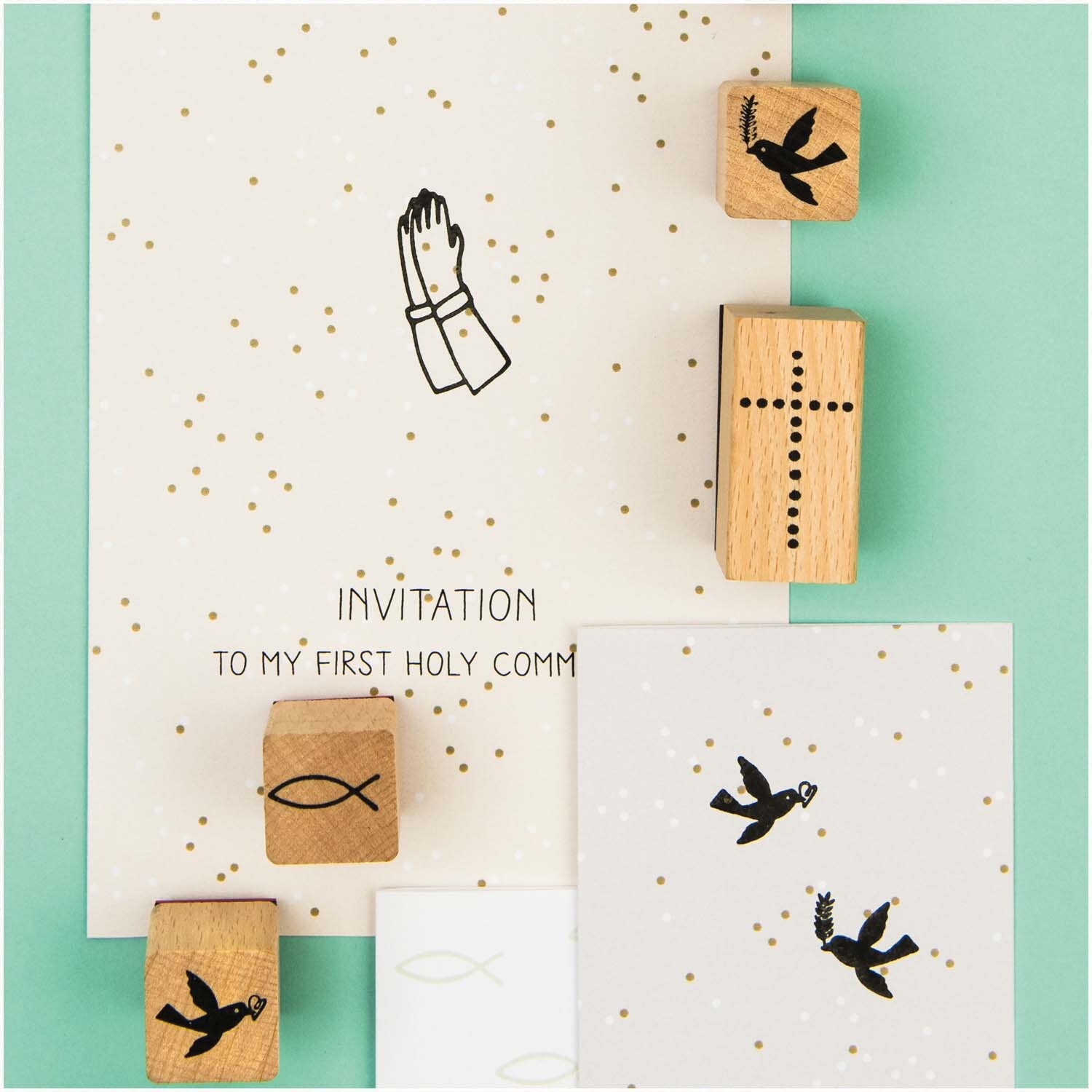 Paper Poetry Stempelset Christliche Feste mit 11 Stempeln, darunter Symbole wie Kreuz und Taube, auf Einladungskarten. Ideal für religiöse Anlässe.
